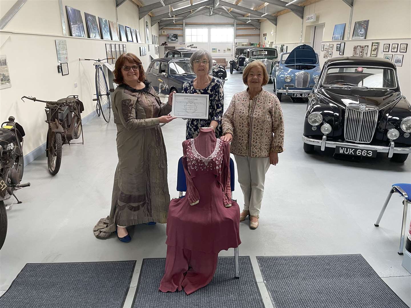 Margaret Thomson (left) handed over the vintage clothing to Janet Mowat (centre), secretary of the Halkirk Heritage and Vintage Motor Society and society member Nancy Swanson. Picture: Eswyl Fell