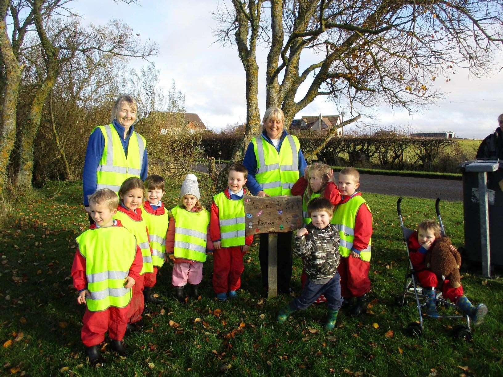 Early years practitioners Grace Gunn and Marchael Dunnet with the children from Watten pre-school who made an anti-litter sign as part of their work to renew their Eco-Schools Green Flag.