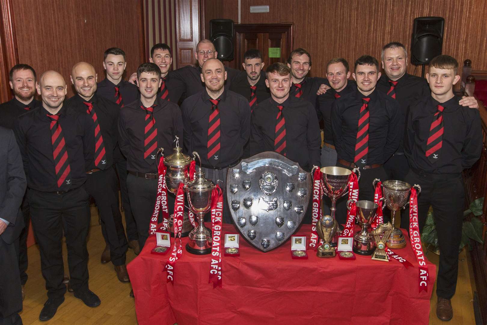 Wick Groats players and management pose for a photo during their annual awards night in the Seaforth Highlanders' Club on Saturday. They had a clean sweep of all the trophies on offer in the various competitions they played in, taking home the David Allan Shield, Colin Macleod Memorial Cup, Eain Mackintosh Cup, the Caithness Division One trophy, the Wick League title and the Highland Amateur Cup, which they have now won four times in the last seven years. Pictures: Robert MacDonald / Northern Studios