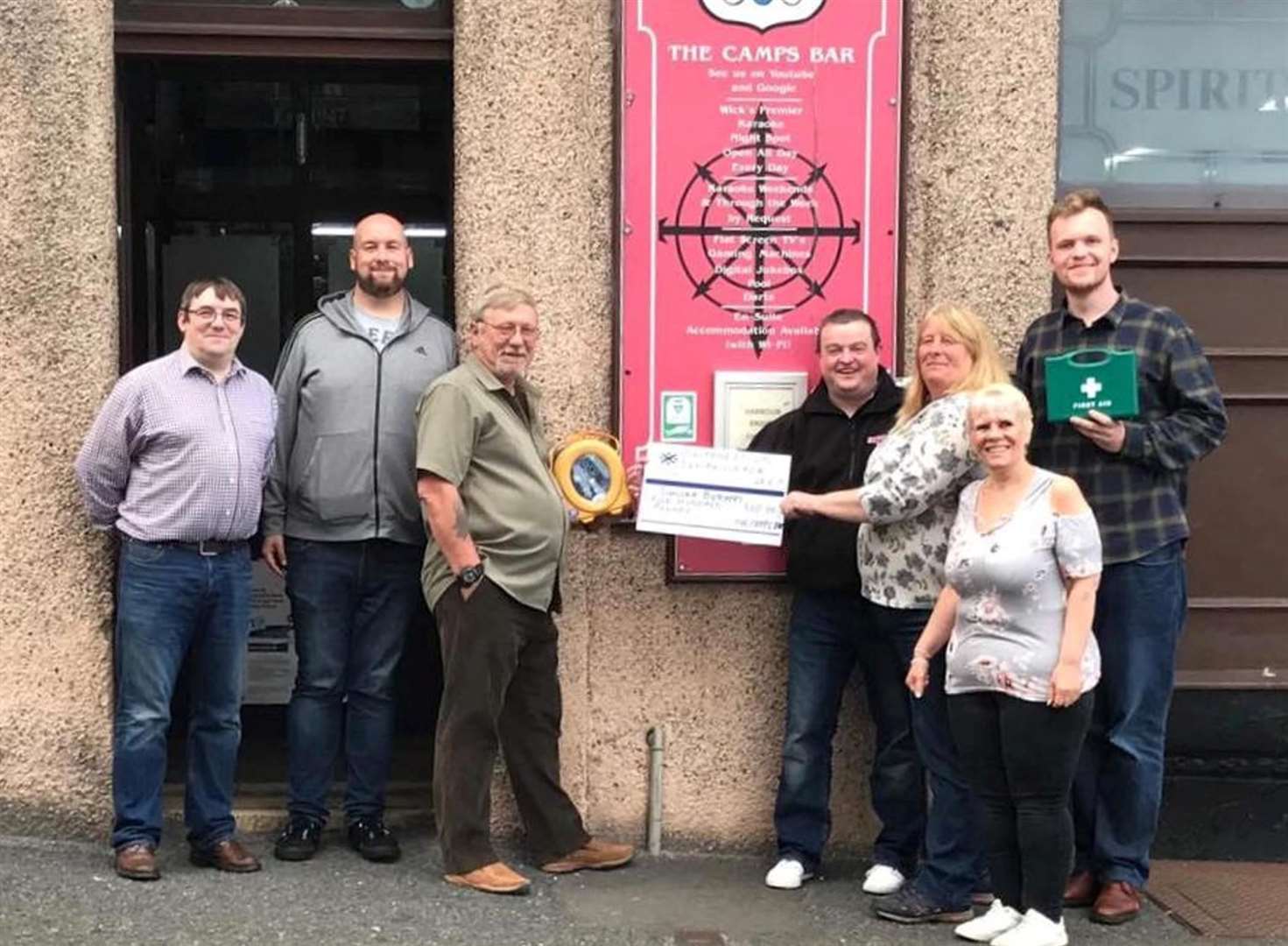 Staff from the Camps Bar present a £500 cheque to Graeme Doull from Sinclair Butchers towards the cost of a defibrillator to serve the Pulteneytown side of the town. From left: Callum Reid, Camps Bar owner, Kevin Boyd, door steward/bartender, William Bruce, door steward, Graeme Doull, Sinclair Butchers, Janet Banks, door steward, Shona Gunn, bartender, and Nick Hodgson, door steward.