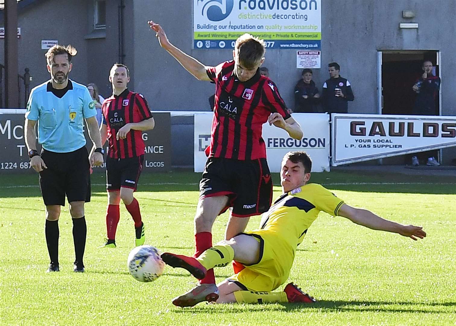 Wick Academy's Ryan Campbell slides in to tackle Andrew Watt of Inverurie Locos. Picture: Mel Roger