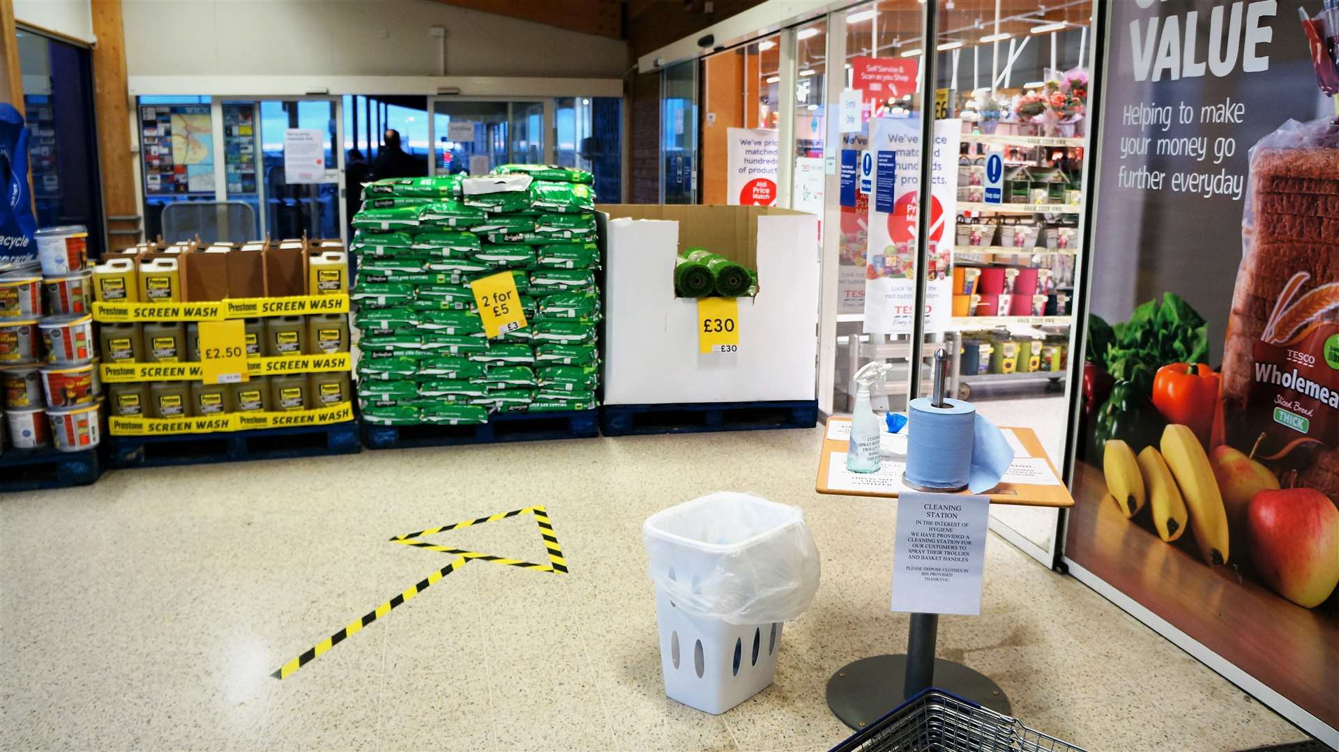 At the entrance to the supermarket are direction arrows and a table with cleaning equipment for trolleys and baskets. Pictures: DGS