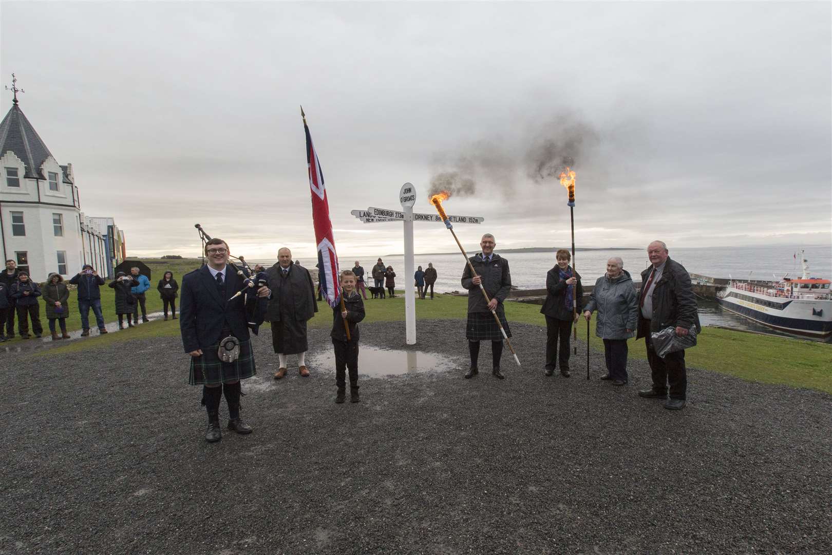 Torch-bearers and others involved in the beacon procession get ready to set off from the John O'Groats signpost. Picture: Robert MacDonald / Northern Studios