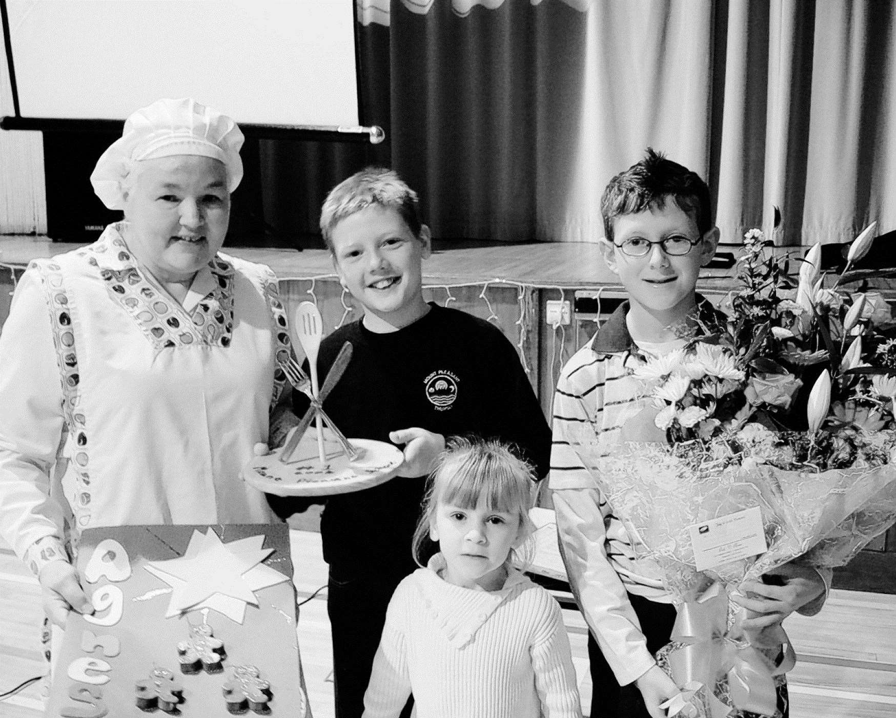 Agnes Andrews, cook in charge at Mount Pleasant school, received gifts from pupils Callum McClelland, Ryan Riddell and Caitlin Farquhar to mark her retirement in December 2006.