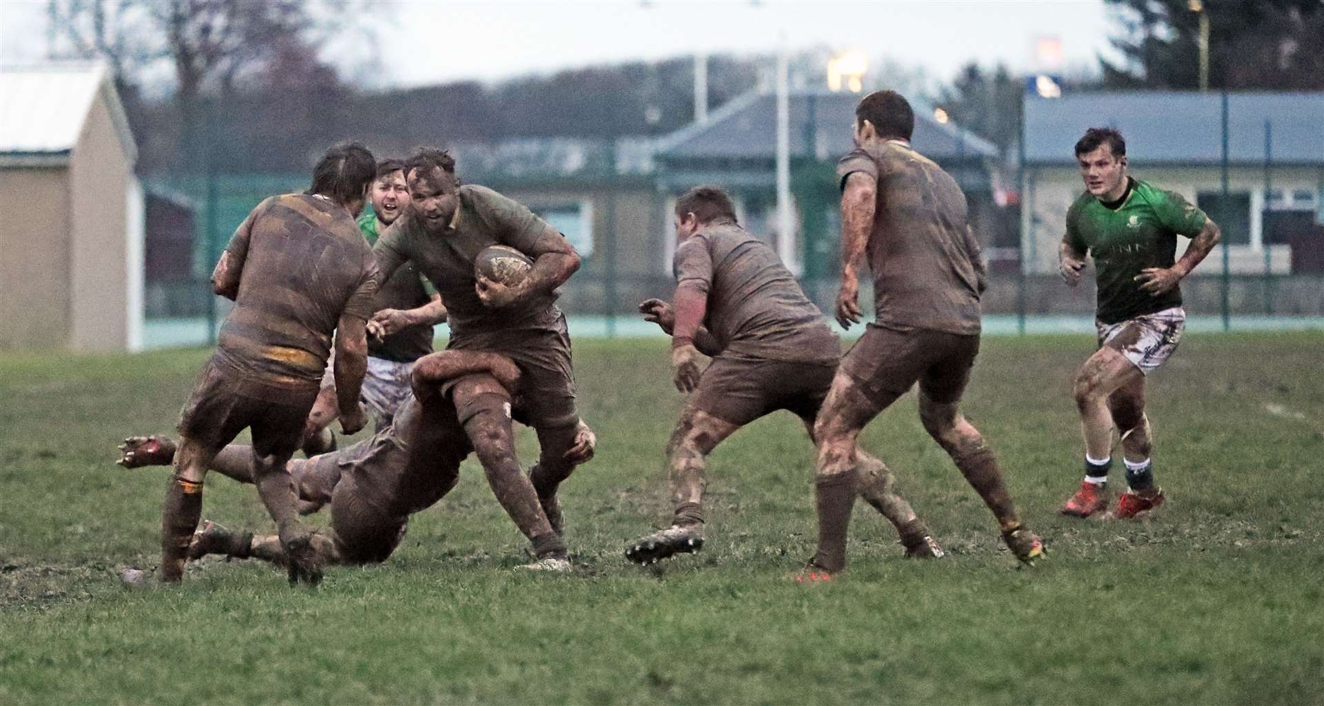 Grant Anderson is tackled as the muddy conditions make it difficult to distinguish one team from the other. Picture: James Gunn