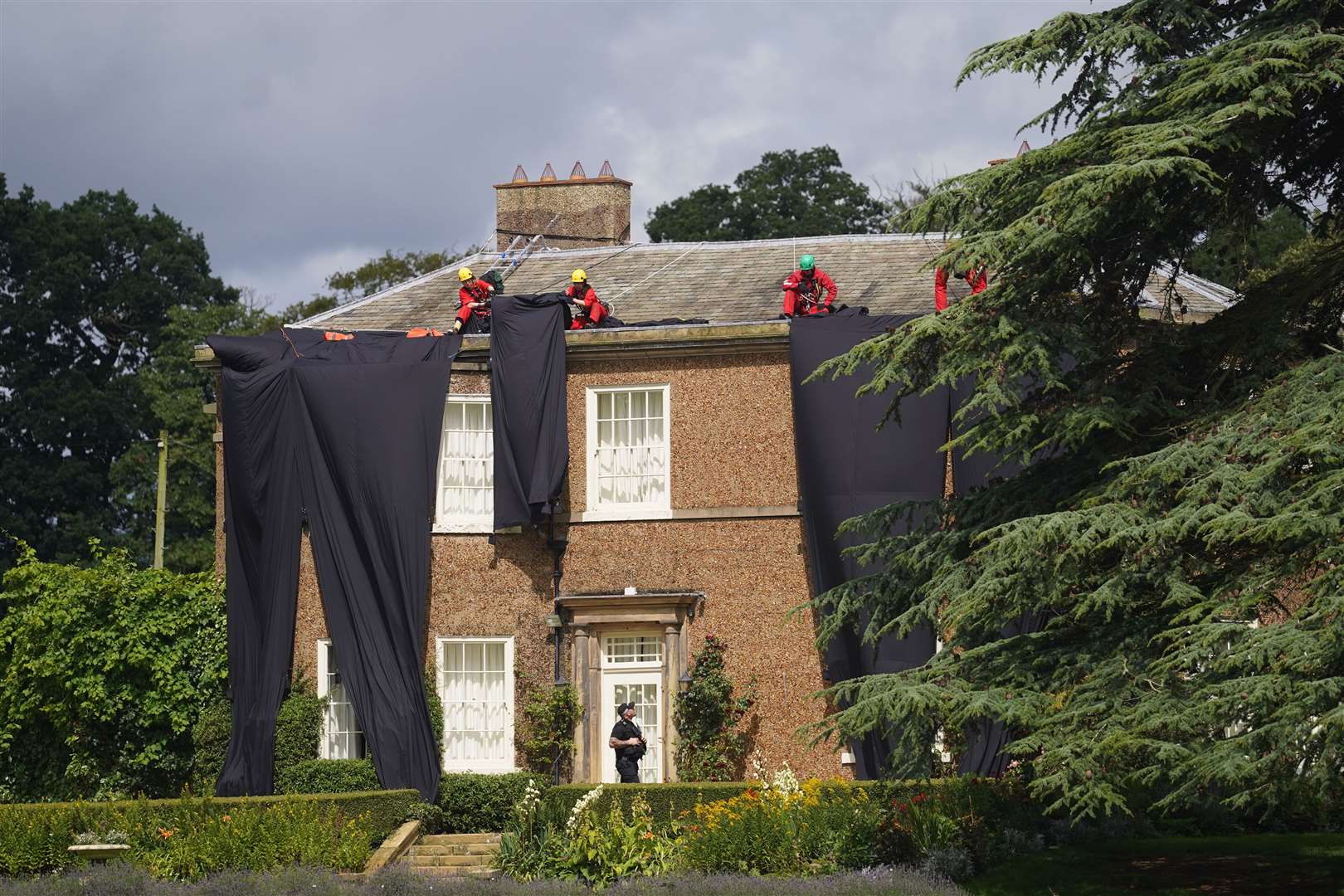 Greenpeace activists moving fabric on the roof of Rishi Sunak’s house in Richmond, North Yorkshire (Danny Lawson/PA)