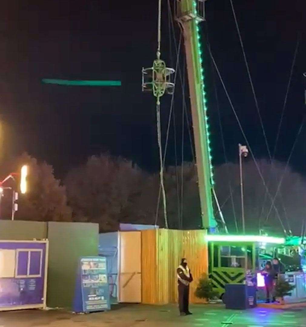 The pod of the Slingshot ride at Winter Wonderland in London’s Hyde Park can be seen dangling in the air with people trapped inside (Becky Littlewood/PA)