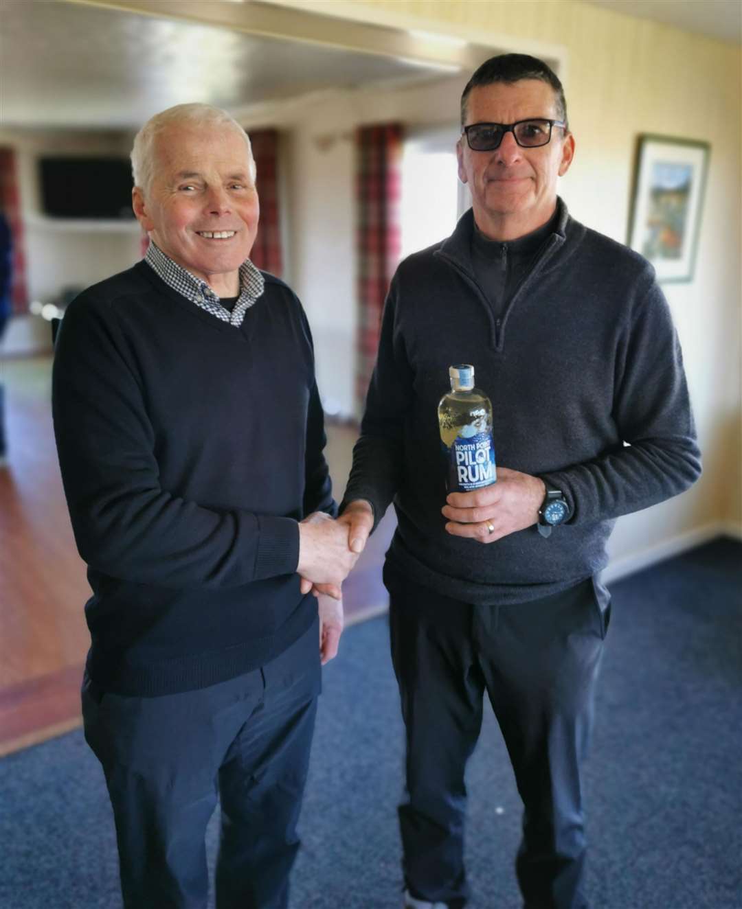 Malcolm Thomson (right) receives a bottle of North Point rum courtesy of the sponsors from Sandy Chisholm, Reay seniors convener.