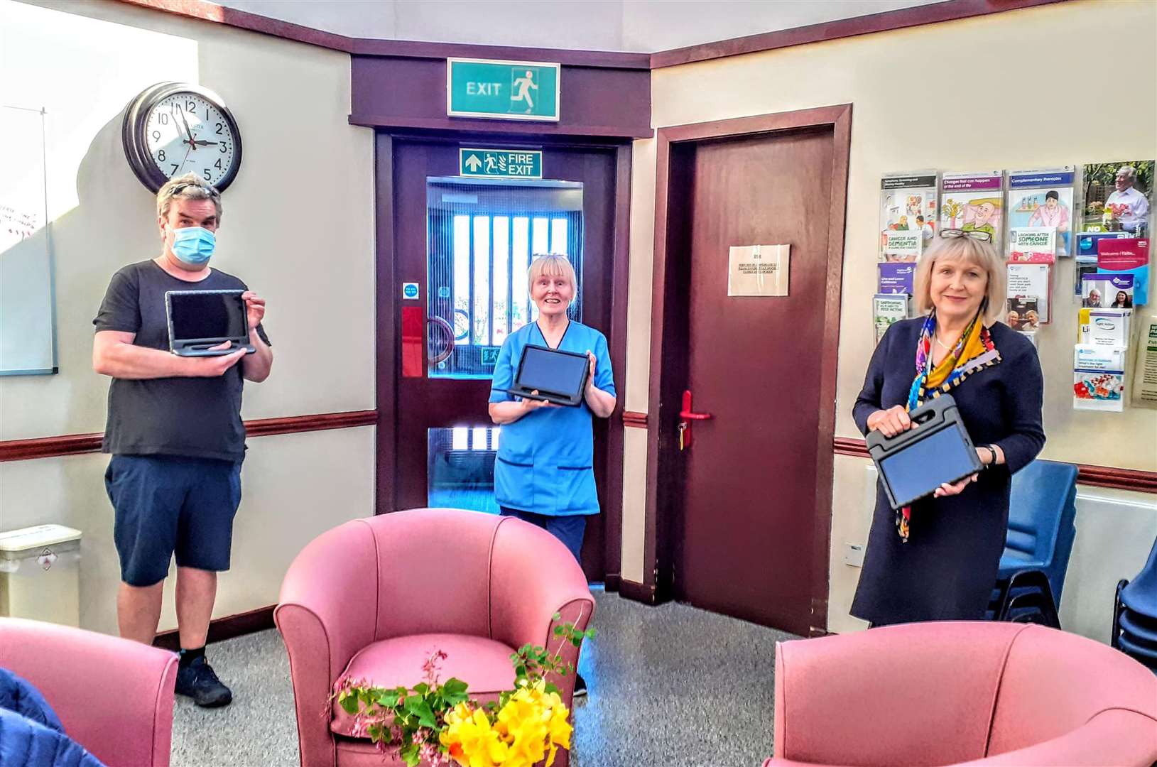 Derek Bremner of Caithness Health Action Team handing tablets to charge nurse Agnes Newton and rural general hospital manager Pam Garbe.
