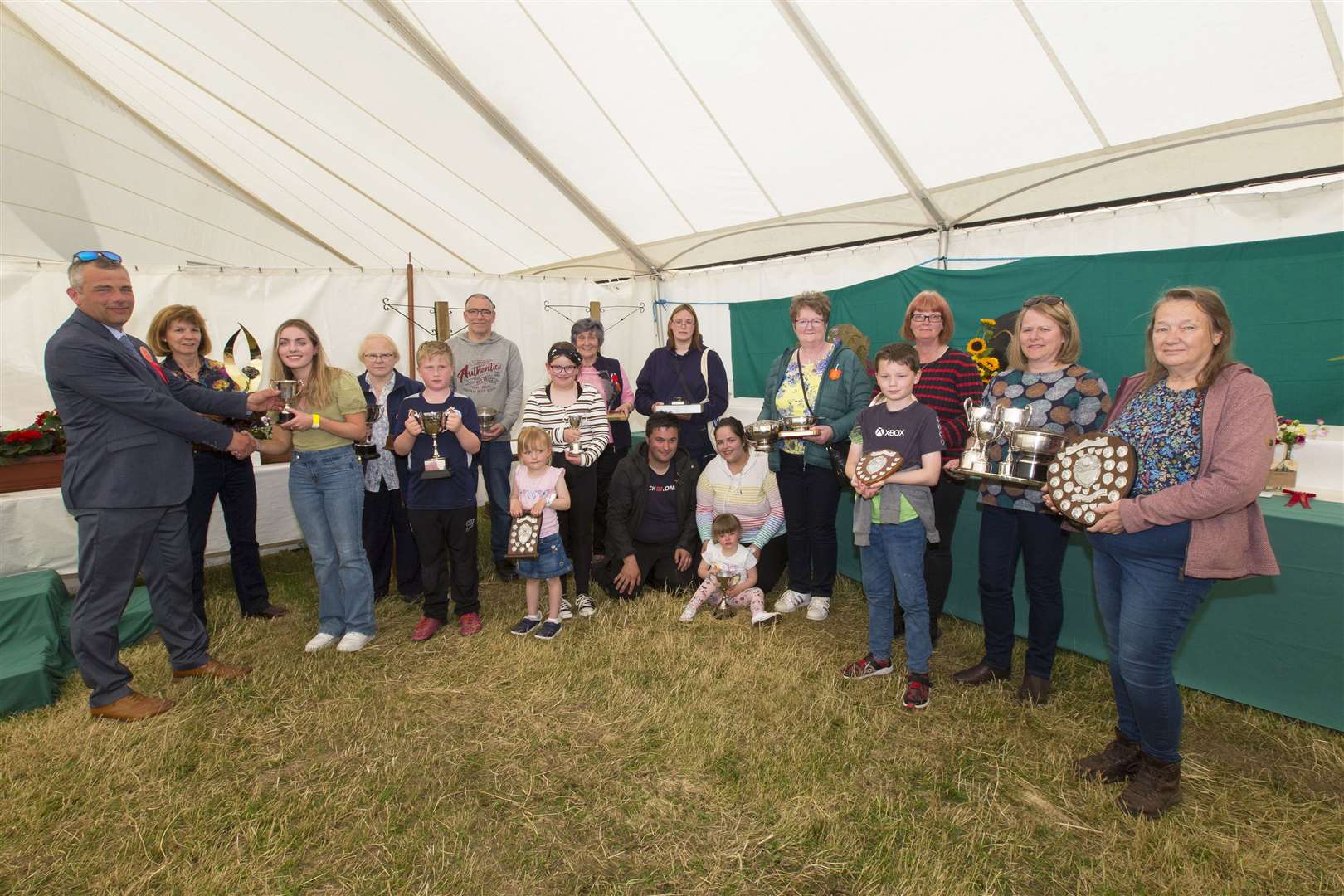 Caithness Agricultural Society president John Murray presents the overall junior trophy to Mirissa Efemey, while looking on are other flower show trophy-winners. Carol Grant (second left) won the Elspeth Sutherland Memorial Trophy, a new award for most points overall. Picture: Robert MacDonald / Northern Studios