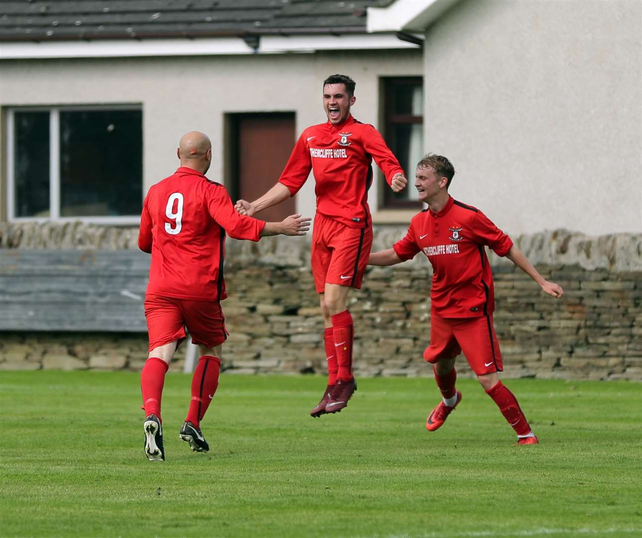 Wick Groats' Ben Sinclair jumps in celebration after scoring their second goal against Pentland United. Sandy Sutherland [number nine] and Mark Macadie rush to congratulate him. Picture: James Gunn