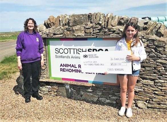 Cerys Norburn, right, hands over a £200 cheque to Christine Urquhart, the manager of the Caithness and Sutherland Animal Rescue and Rehoming Centre at Balmore.