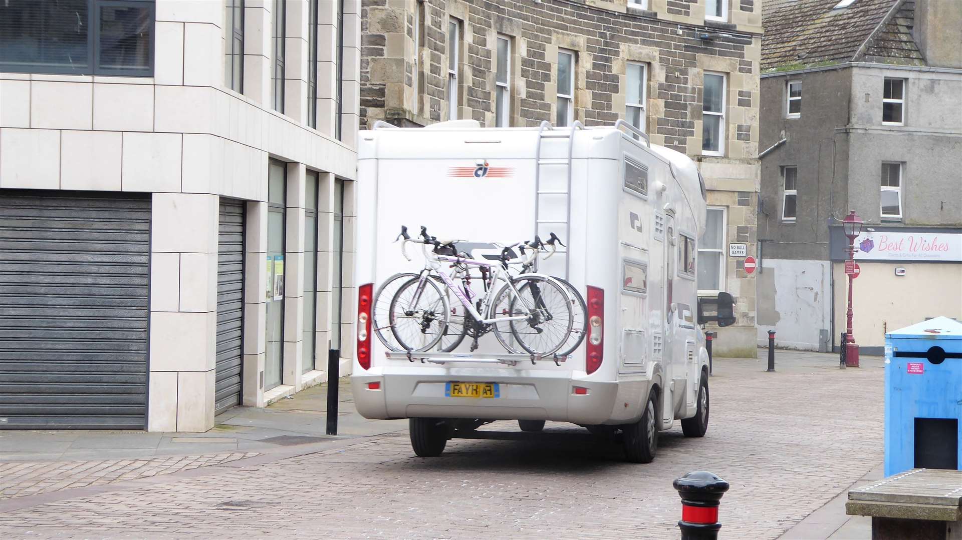 A motorhome travelling through the town square.