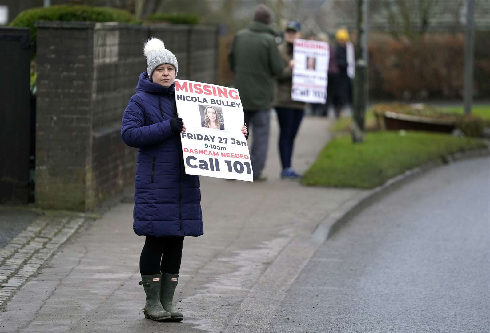 Members of the public line the road into St Michael’s on Wyre, Lancashire, with missing posters of Nicola Bulley (Danny Lawson/PA)