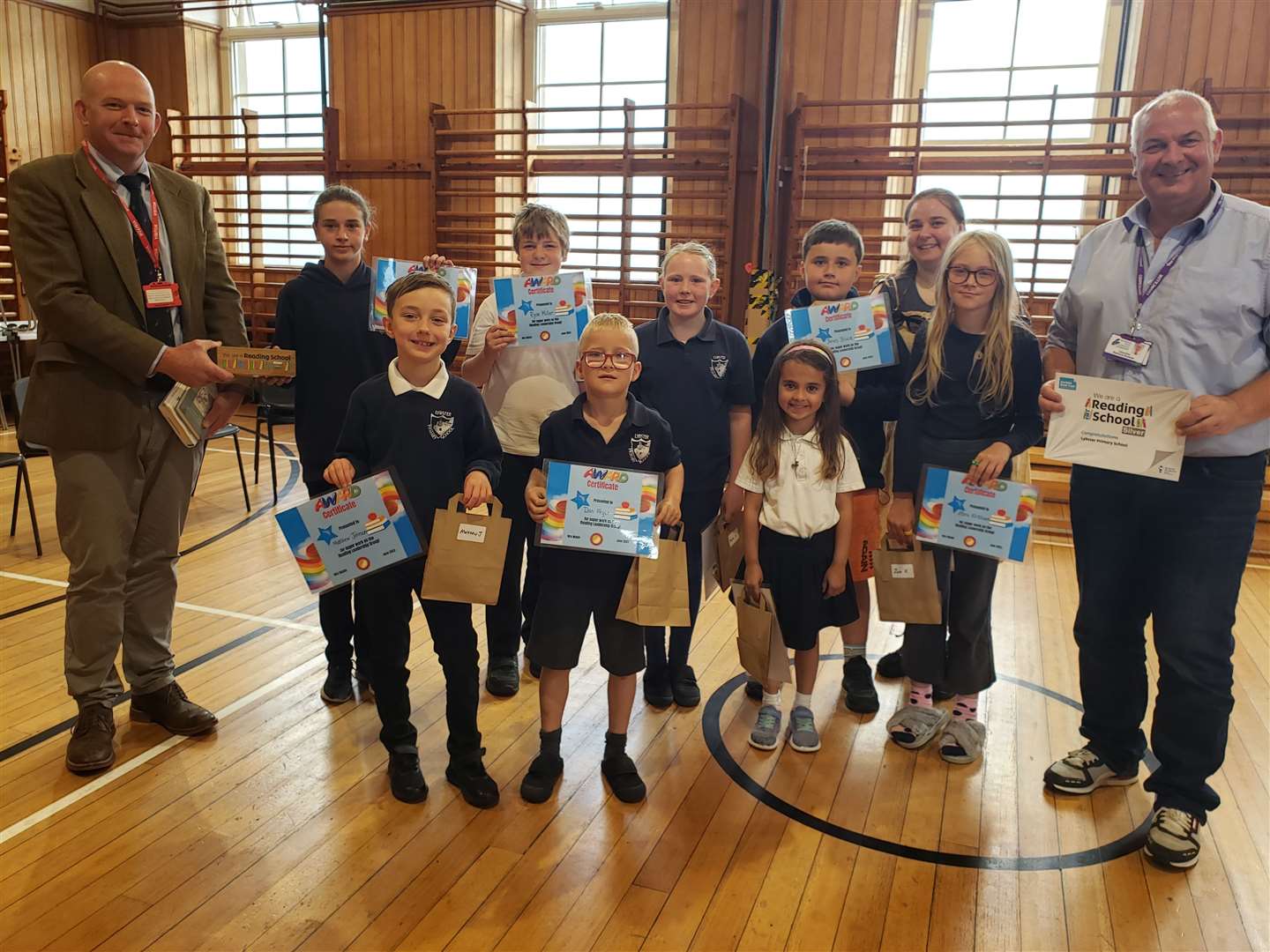 Anson Macauslan (left) of the Lord-Lieutenant's office and (right) Councillor Raymond Bremner with members of Lybster Primary's Reading Leadership Group (back, from left) Lucy Dimes, Ryan Miller, Ailsa Chisholm, Innes Black, teacher Judith Crow, Zara Kirkham; (front) Matthew Johnson, Dan Fryer and Josselin Sutherland.