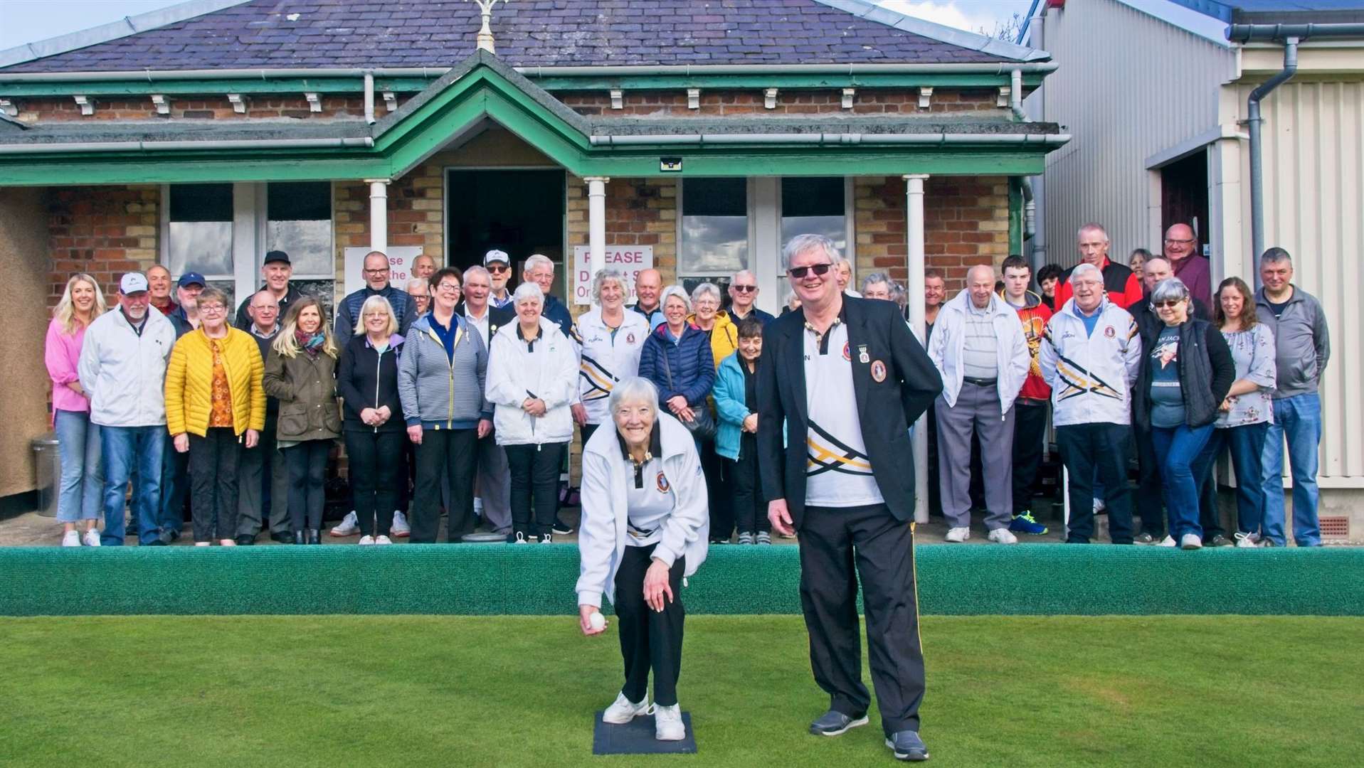 Thurso Bowling Club members watching Lily Wilson throw the first jack of the season.
