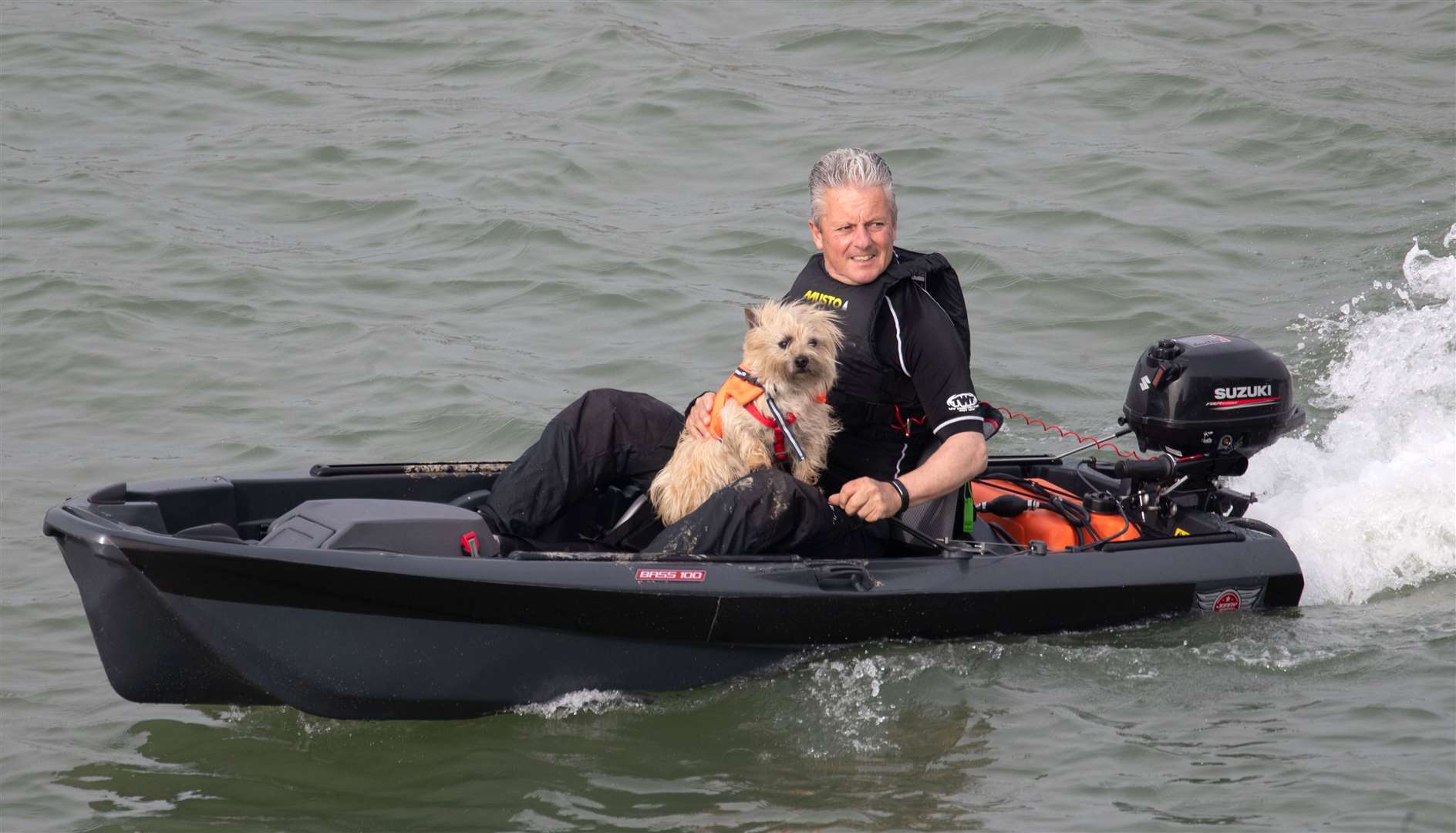 A man and his dog make their way out of Portsmouth harbour in a small boat (Andrew Matthews/PA)
