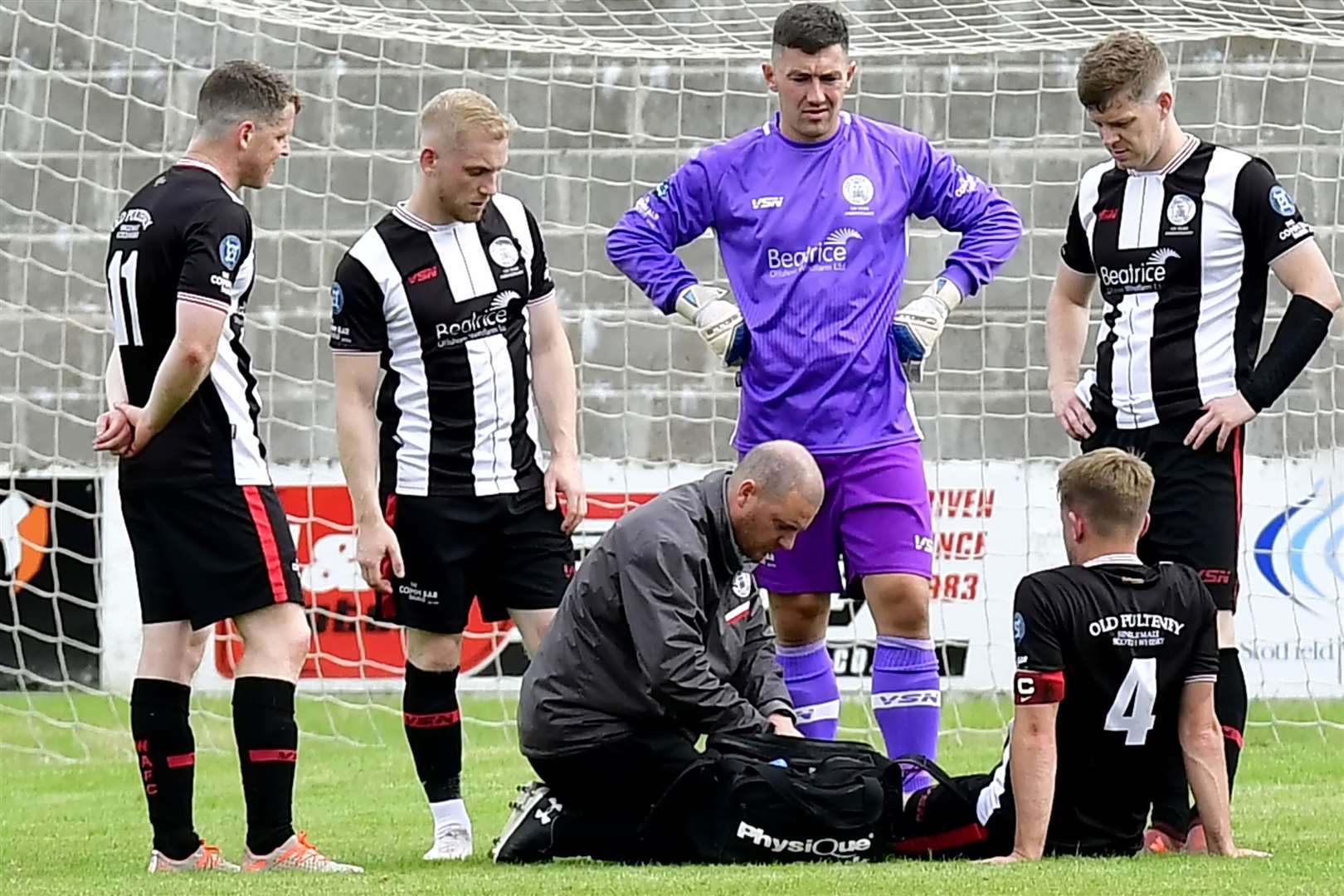Concerned team-mates look on as Alan Farquhar lies injured at Lossiemouth's Grant Park in August 2021. Picture: Mel Roger