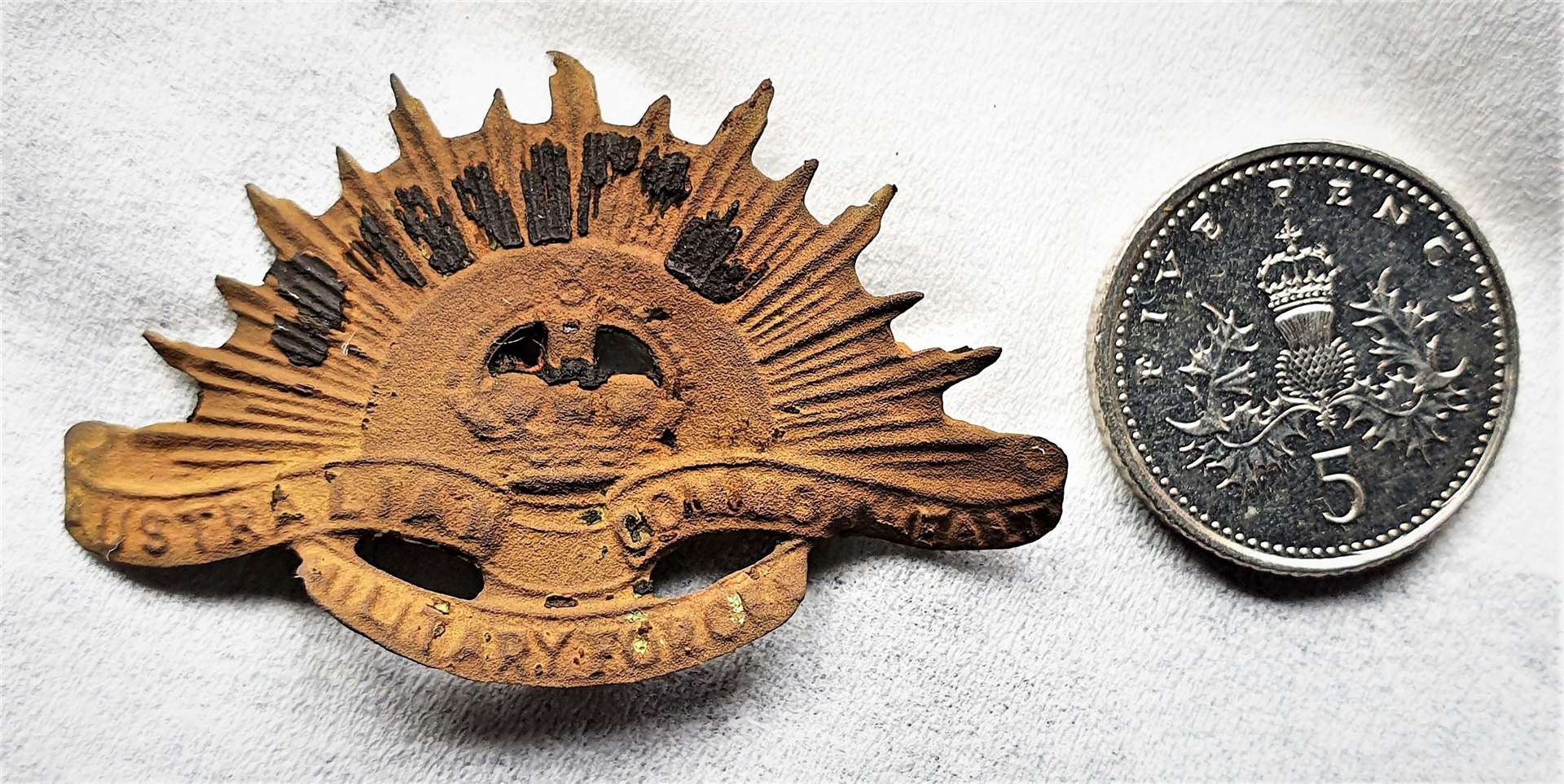 The Australian Rising Sun badge that Chris found with a 5p coin for size comparison. Picture: Chris Aitken