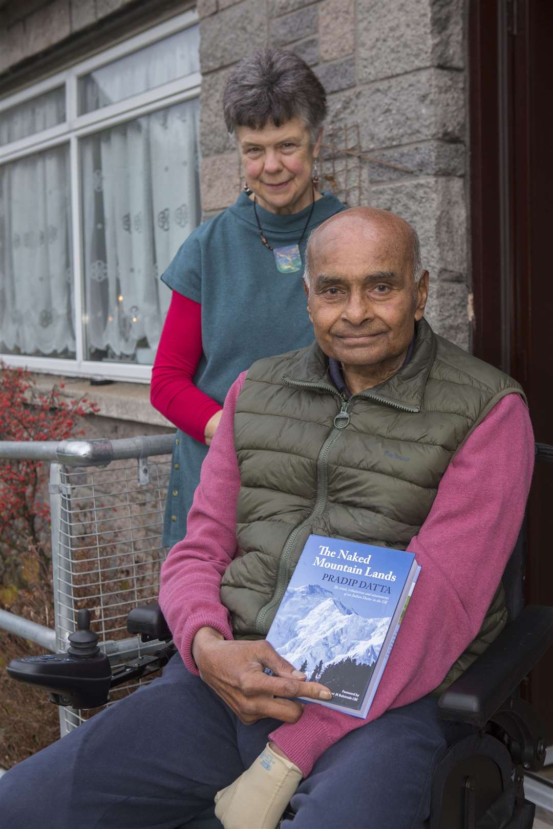 Mr Pradip Datta with his biography – The Naked Mountain Lands – which outlines his arrival in the UK from India, and a lifetime as a surgeon, much of which was spent working in Caithness, where he still lives. Also in the photograph is his friend Dr Loretta Davis-Reynolds, who has been helping him since he suffered a stroke. Picture: Robert MacDonald/Northern Studios