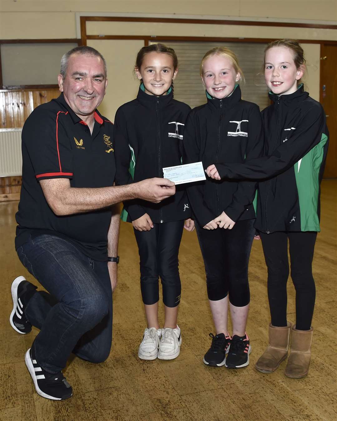 Girls from Caithness Gymnastics accepting their cheque from Albert Mcivor. Picture: Mel Roger