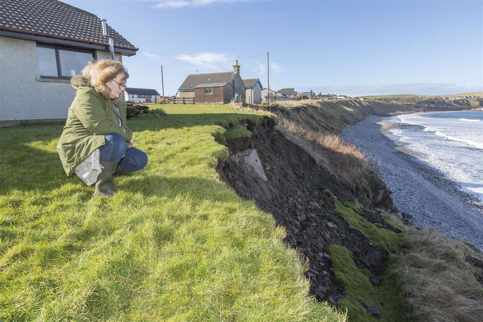 Shirley Hardie beside the landslip that has brought the cliff edge to within 4.5 metres of her home at East Gills, Scrabster. Picture: Robert MacDonald / Northern Studios