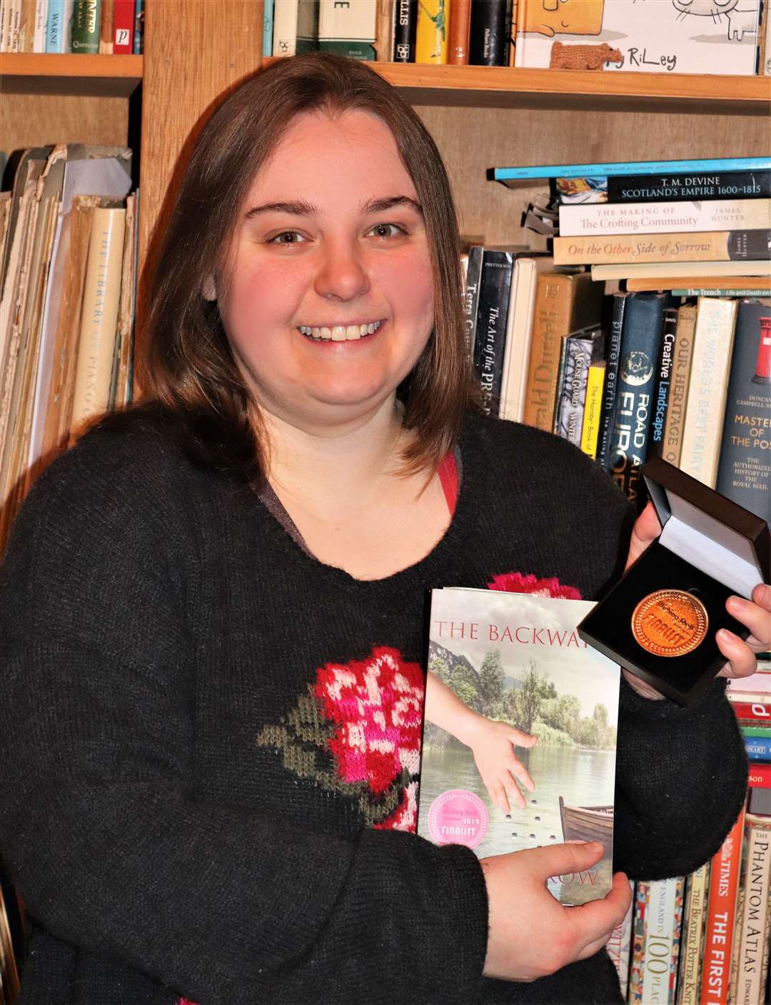 Noss Primary teacher Judith Crow with her novel The Backwater and the finalist medal she received from a prestigious book awards.