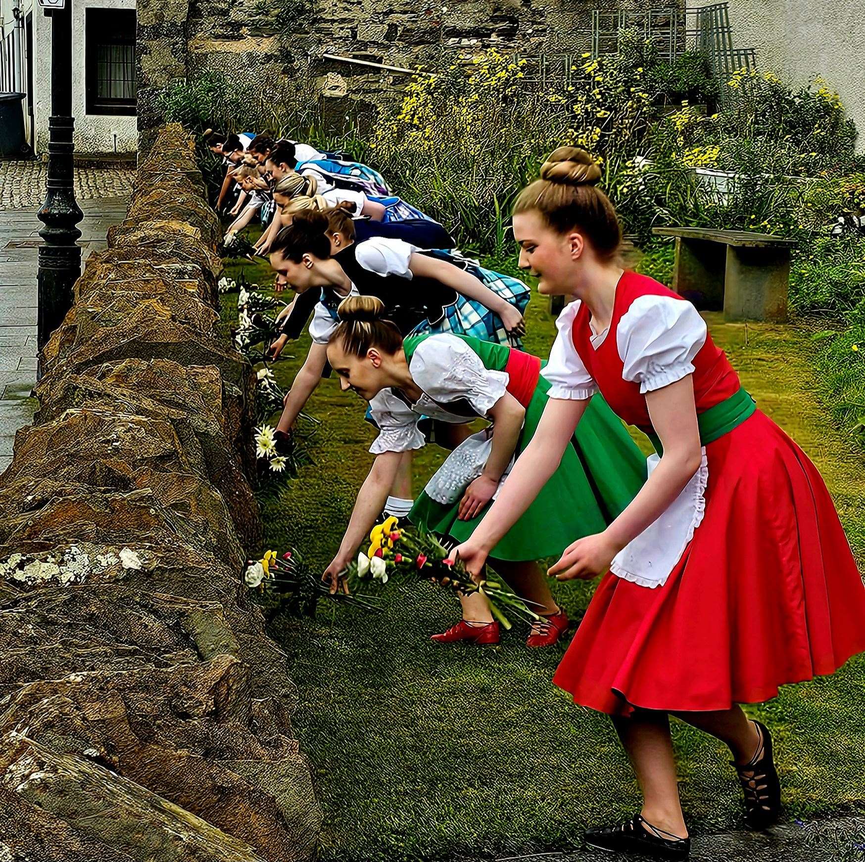 Some of Elise Lyall's dancers laying flowers at the memorial garden in Bank Row on Saturday. The names of air raid victims are inscribed on individual stones within the drystone wall. Picture: John Mackenzie