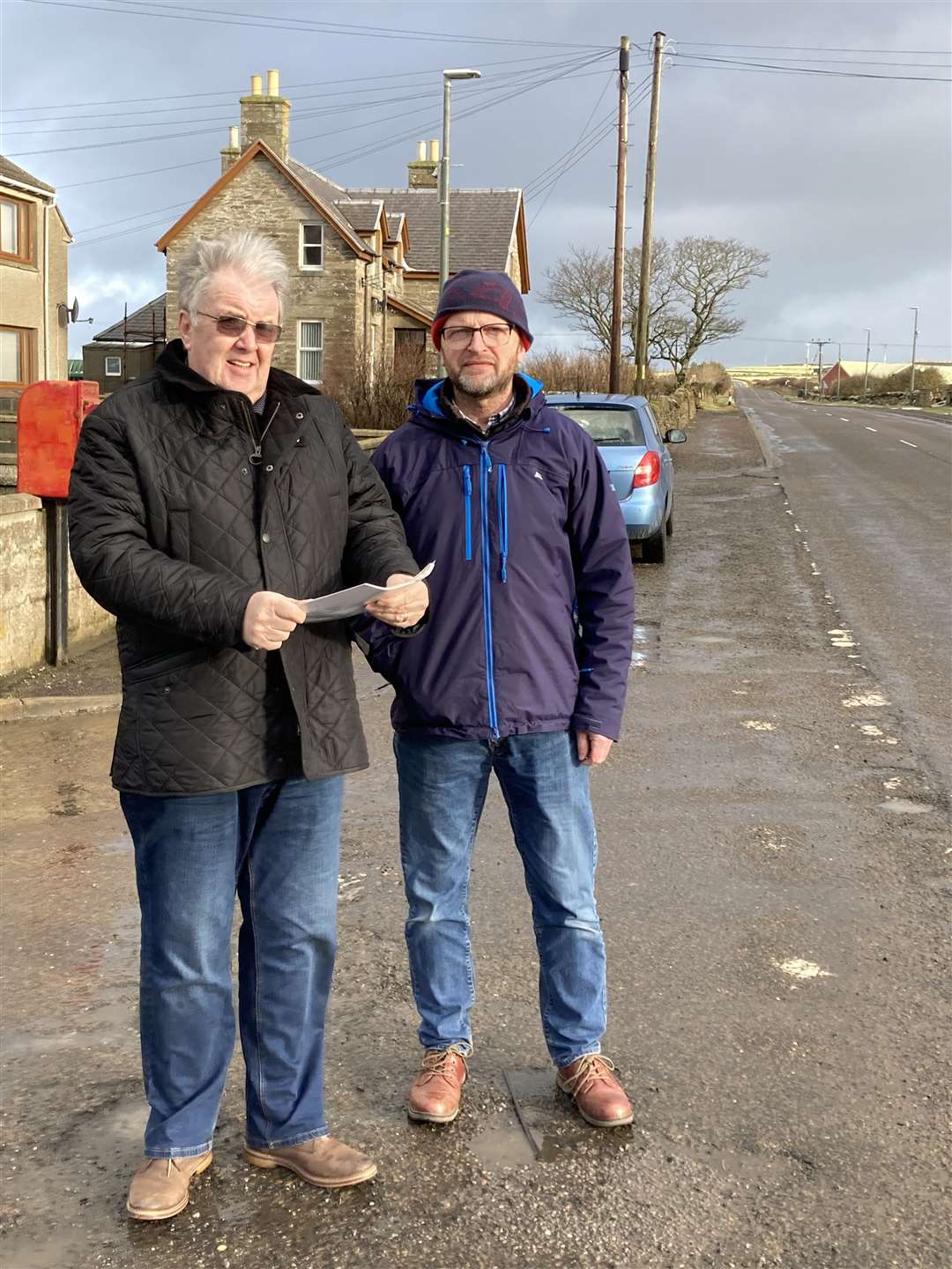 Forss resident John Ross (left) with Councillor Matthew Reiss alongside the Forss straight. Mr Ross is holding the petition he started in 2013. Picture: Alison Reiss