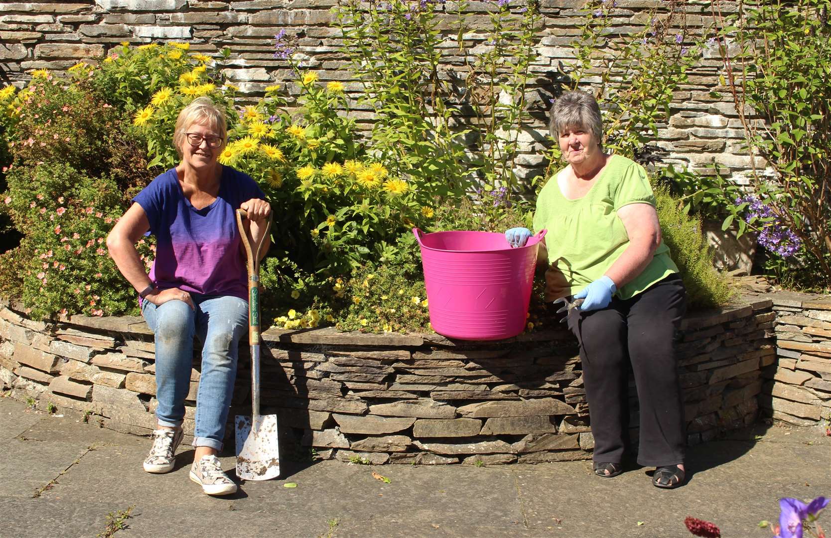 Volunteers Yvonne Hendry (left) and Catherine Miller working in the memorial garden earlier this month.