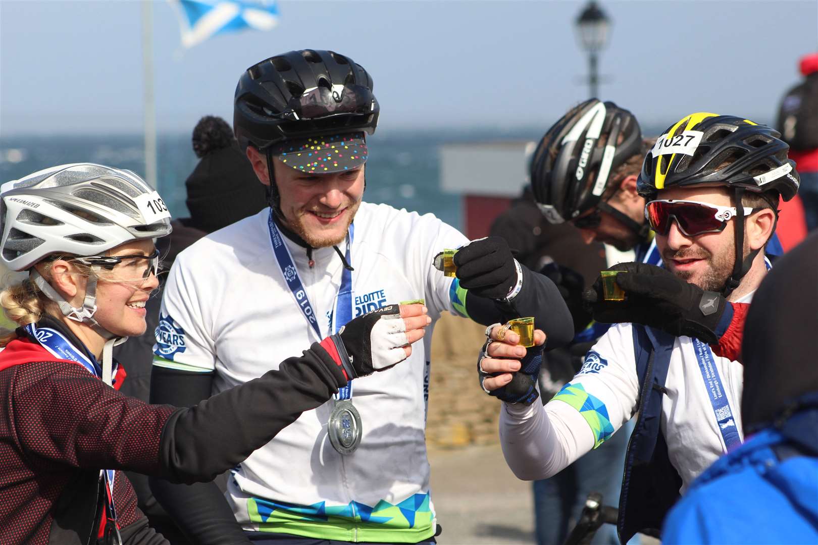 Three of the cyclists share a celebratory drink after completing the Deloitte Ride Across Britain 2019 at John O'Groats. Picture: Alan Hendry