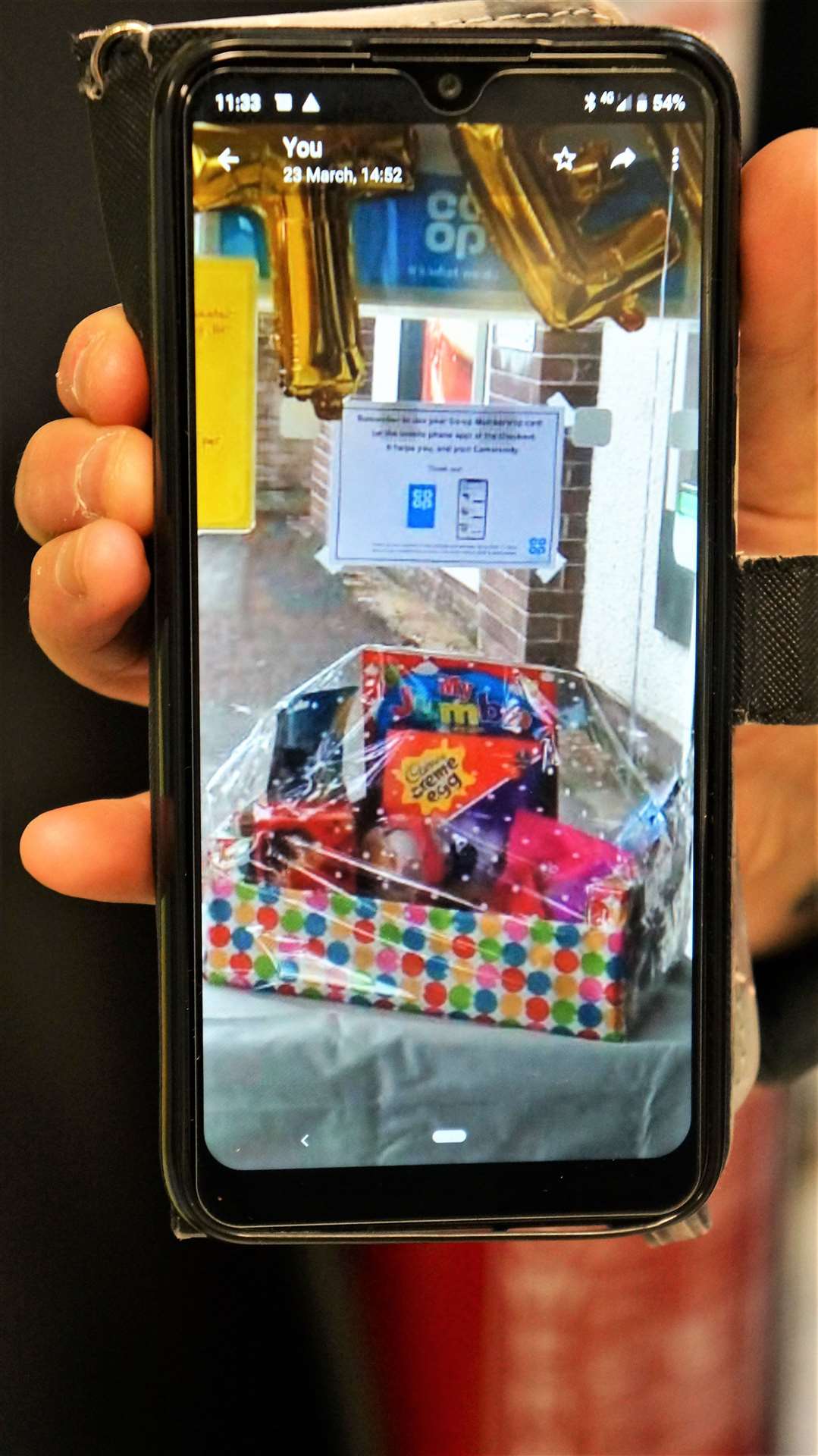 Kirsteen shows on her smartphone what the stolen hamper looked like while on display.