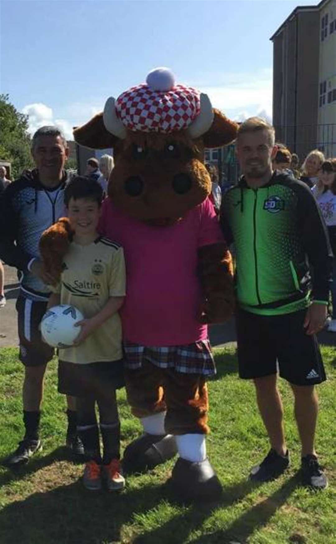 This young Aberdeen fan poses for a snap with former Rangers midfielder, Charlie Miller (left), ex-Celtic star Simon Donnelly (right) and a cow at the football coaching course at Thurso's Mount Pleasant school.