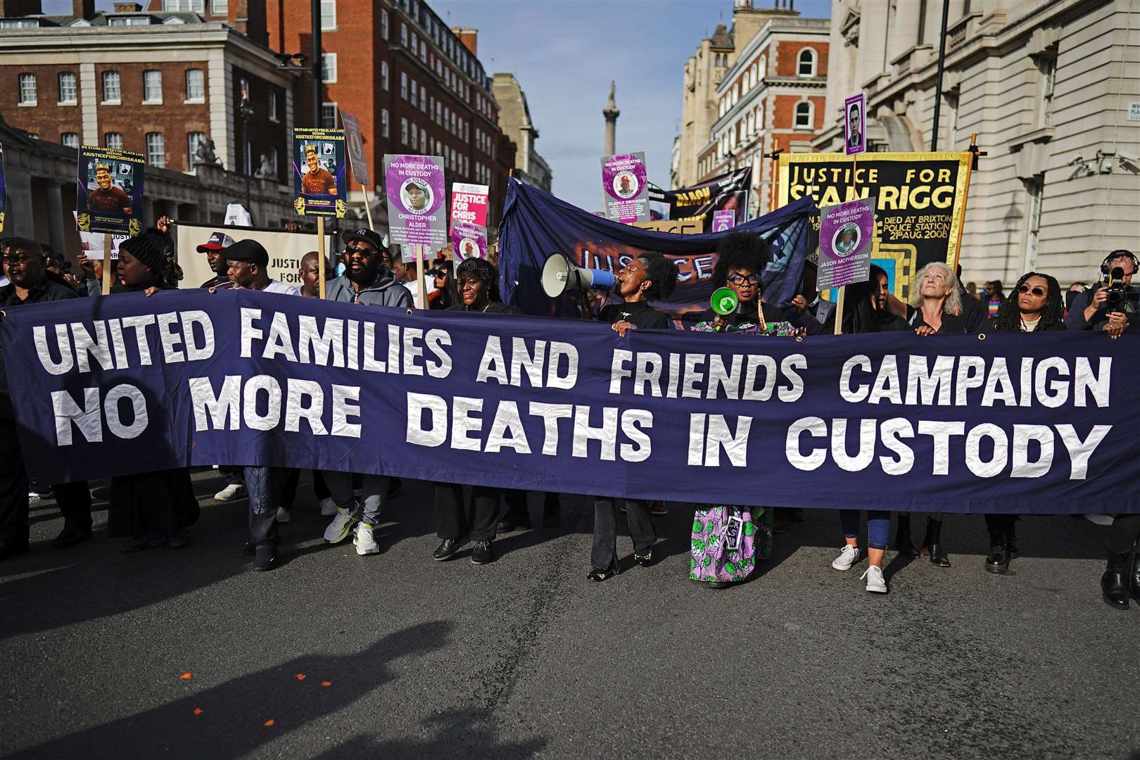 The protesters march behind a banner in central London (Aaron Chown/PA)