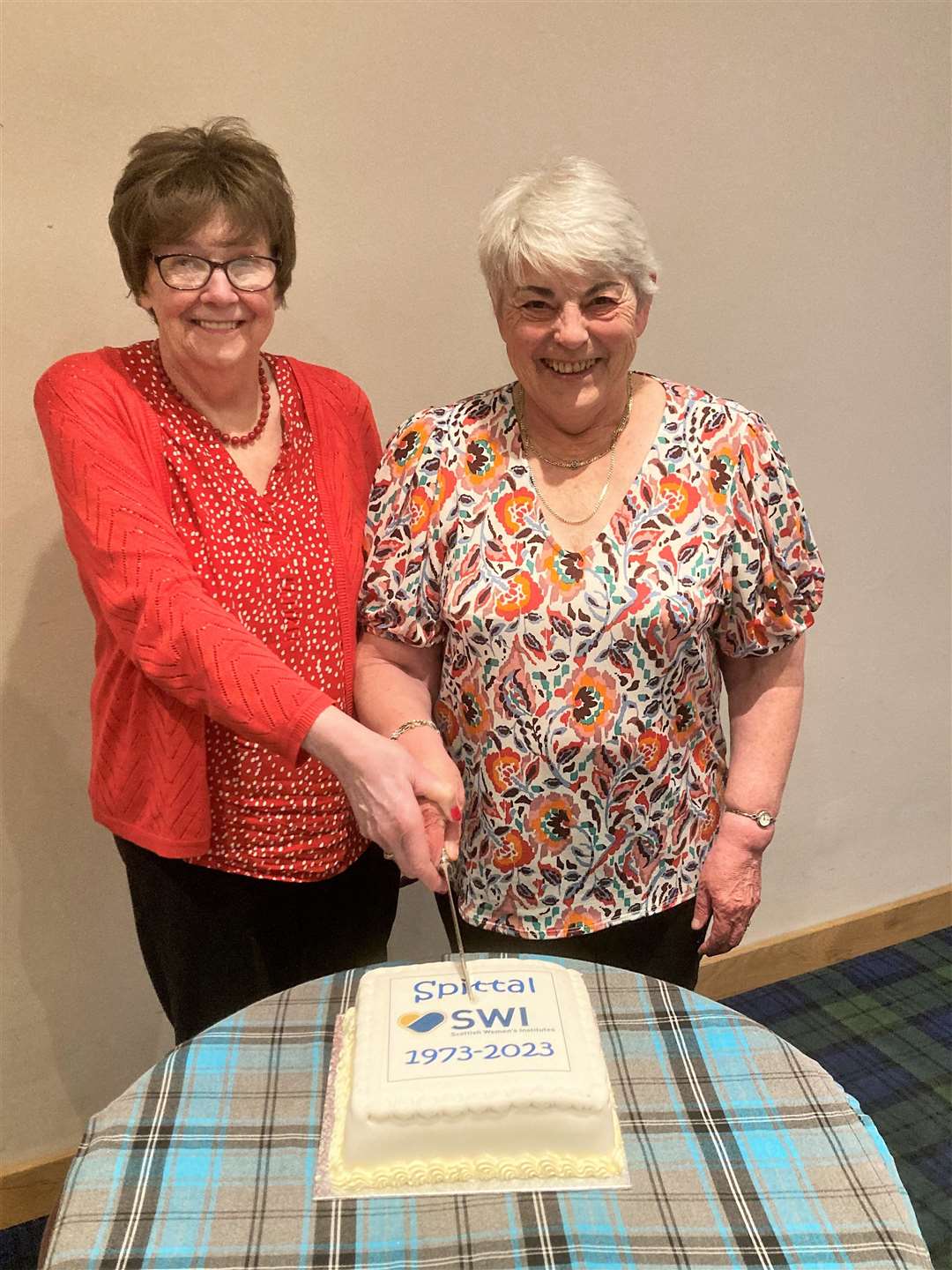 Spittal SWI founder members Jean Watt, left, and Linda Levack cutting the special 50th birthday cake.