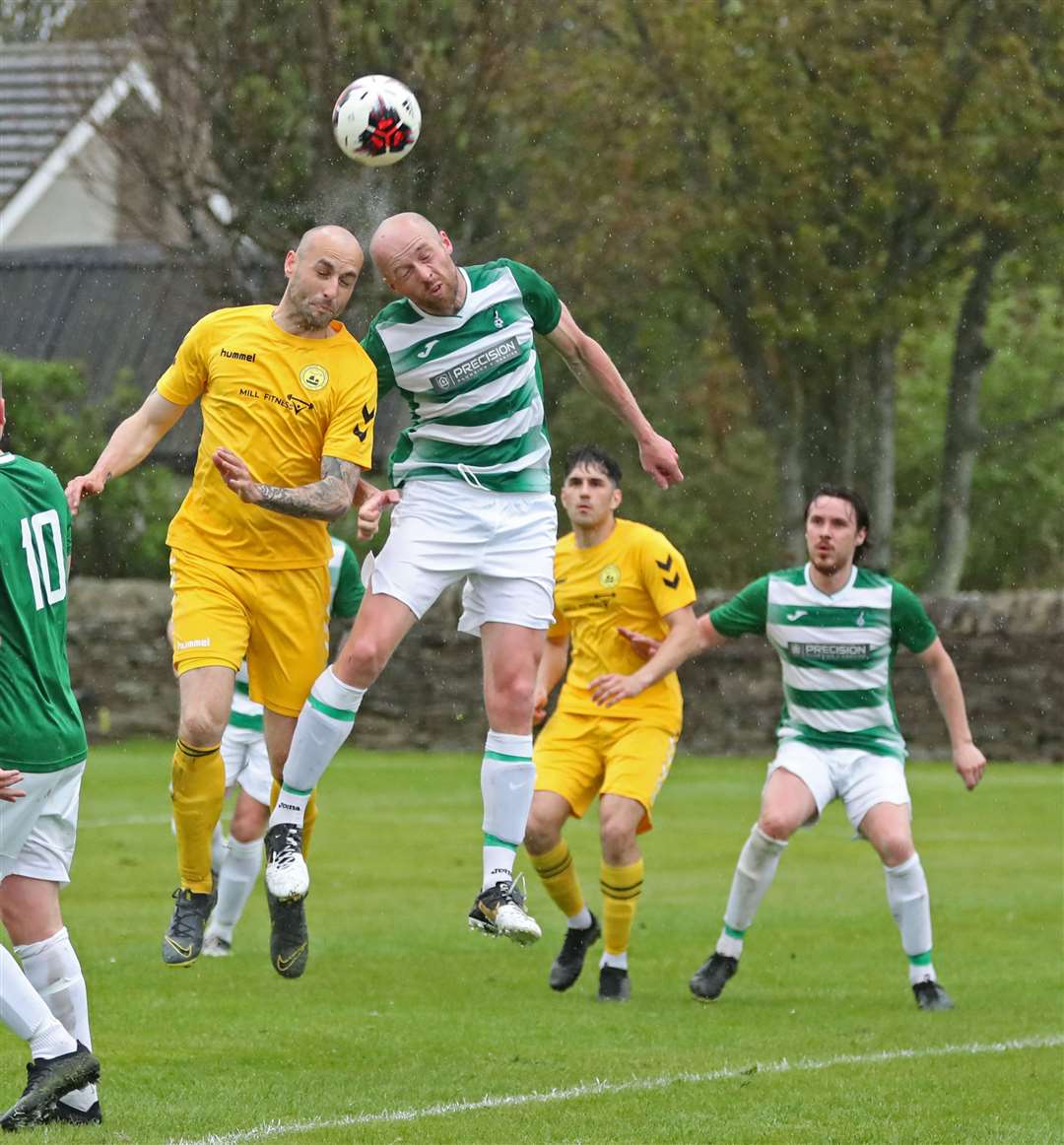Staxigoe's Darren Sheppard and Castletown's James Harris in an aerial duel at a rainy Back Park. Picture: James Gunn