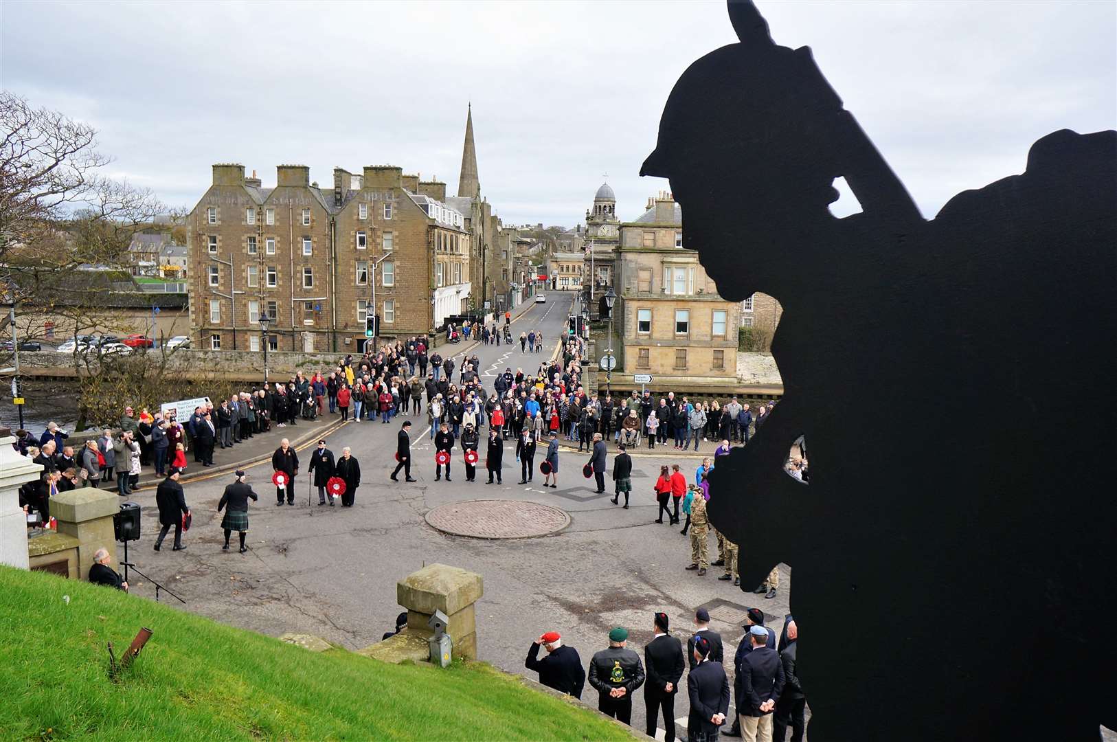One of the soldier silhouettes provided by ex-serviceman Denny Swanson looks down on the ceremony at the Wick war memorial. Picture: DGS