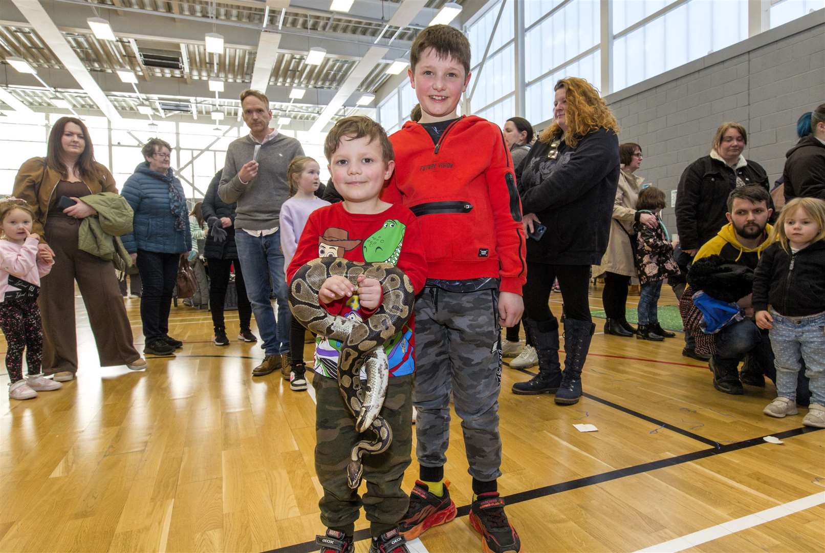 Five-year-old Harvey Norwood and his eight-year-old brother Max, with Sid a royal python, on the Caithness Animal Farm Park stand. Photo: Robert MacDonald/Northern Studios