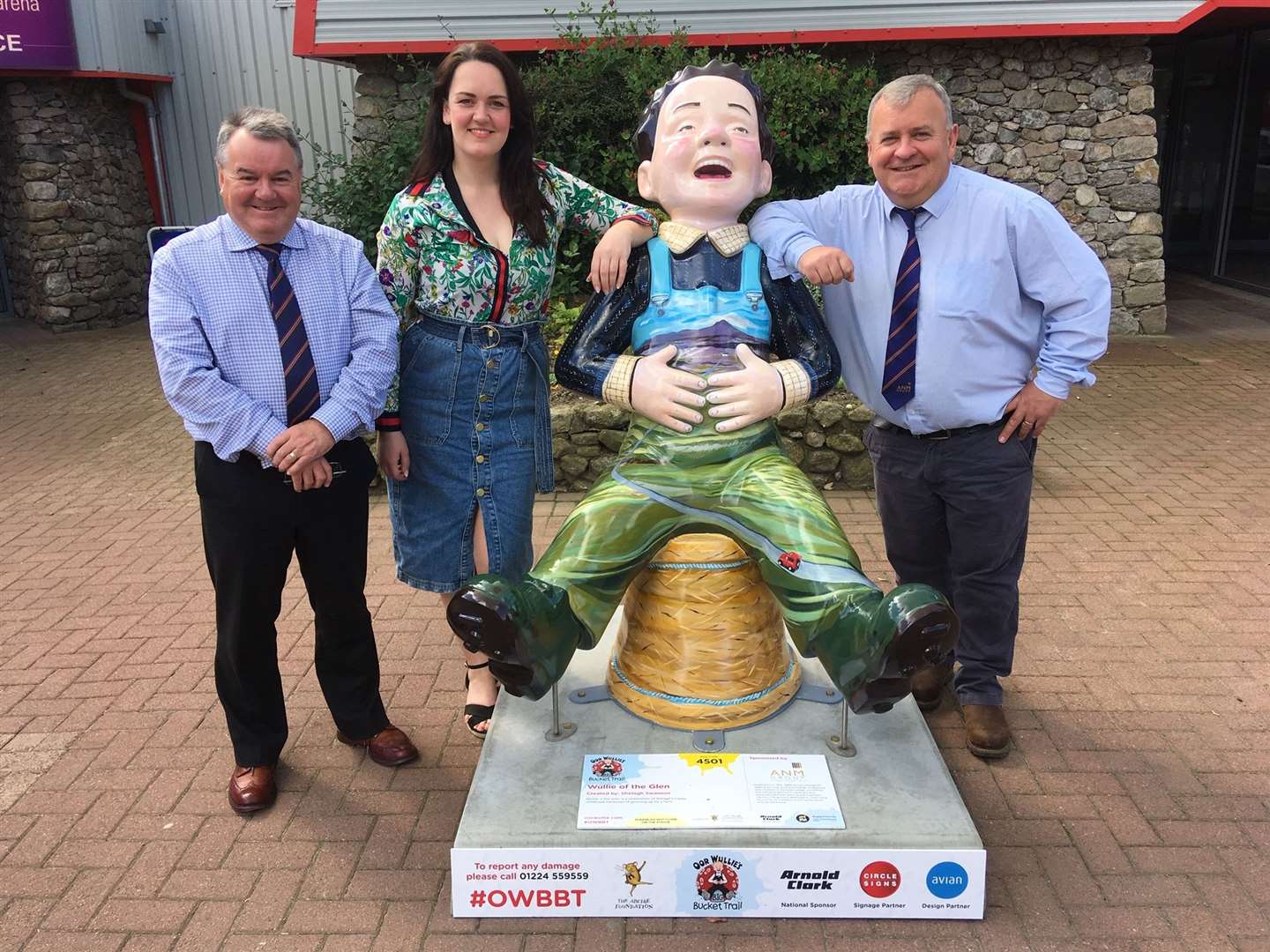 Shelagh Swanson with ANM auctioneers Alan Hutcheon (left) and Colin Slessor beside the Wullie of the Glen sculpture at Thainstone.