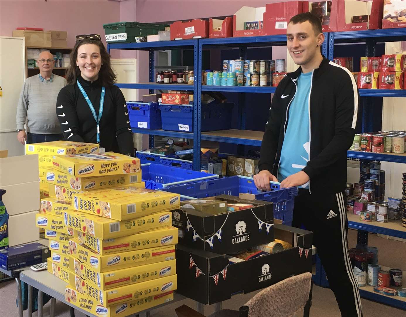 Chloe Mackay and Ryan Edwards from High Life Highland at Caithness Foodbank in Wick, helping with organising food parcels and then delivering them in the community. Looking on is Caithness Foodbank chairman Grant Ramsay.