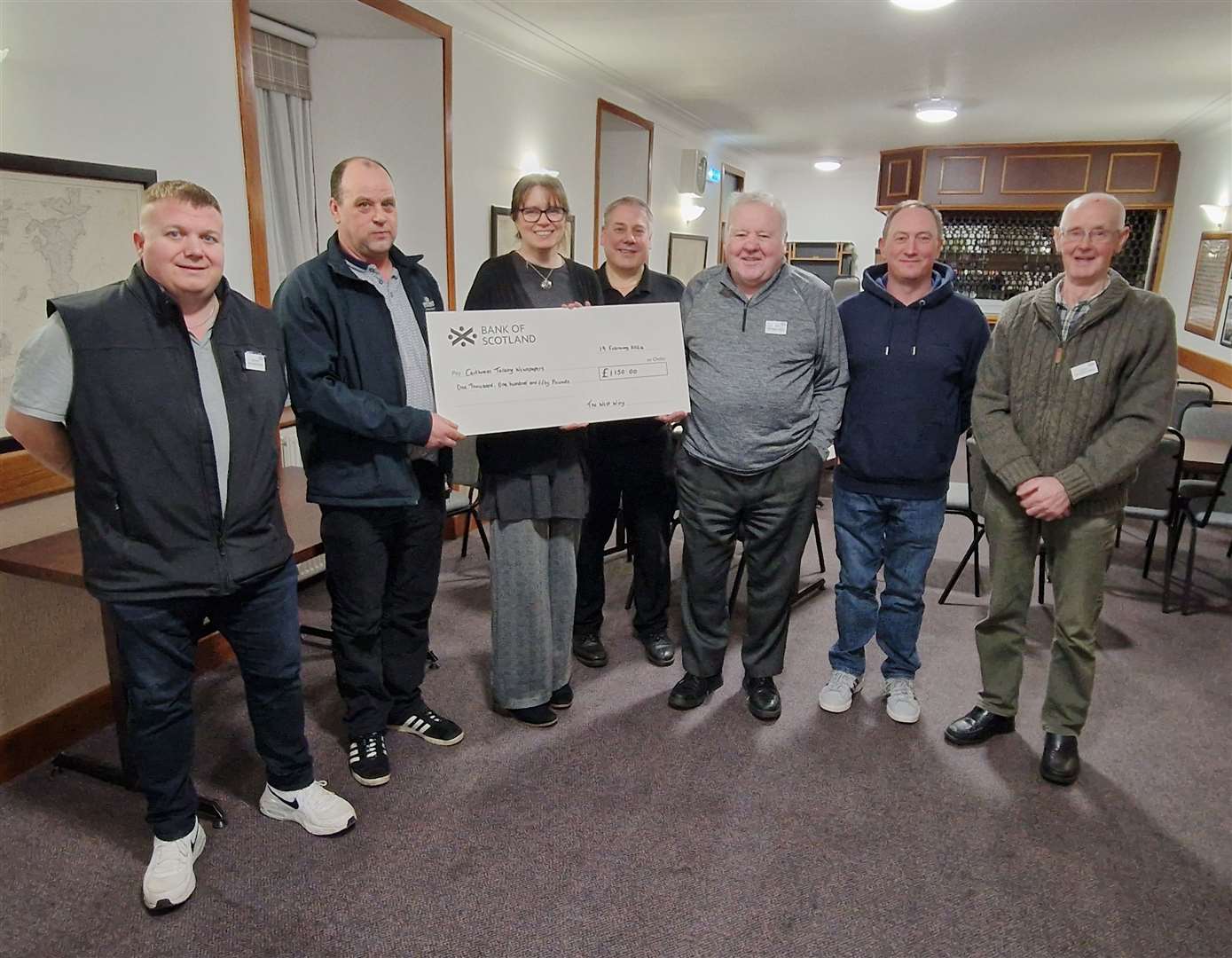 West Wing Crew members presenting the cheque for £1150 to Pauline Gibson (Caithness Talking Newspapers). From left: George Duncan, Kenneth Forbes, Pauline Gibson, Mervyn Hill, Bruce Simpson, Eifion Davies and David Forbes.
