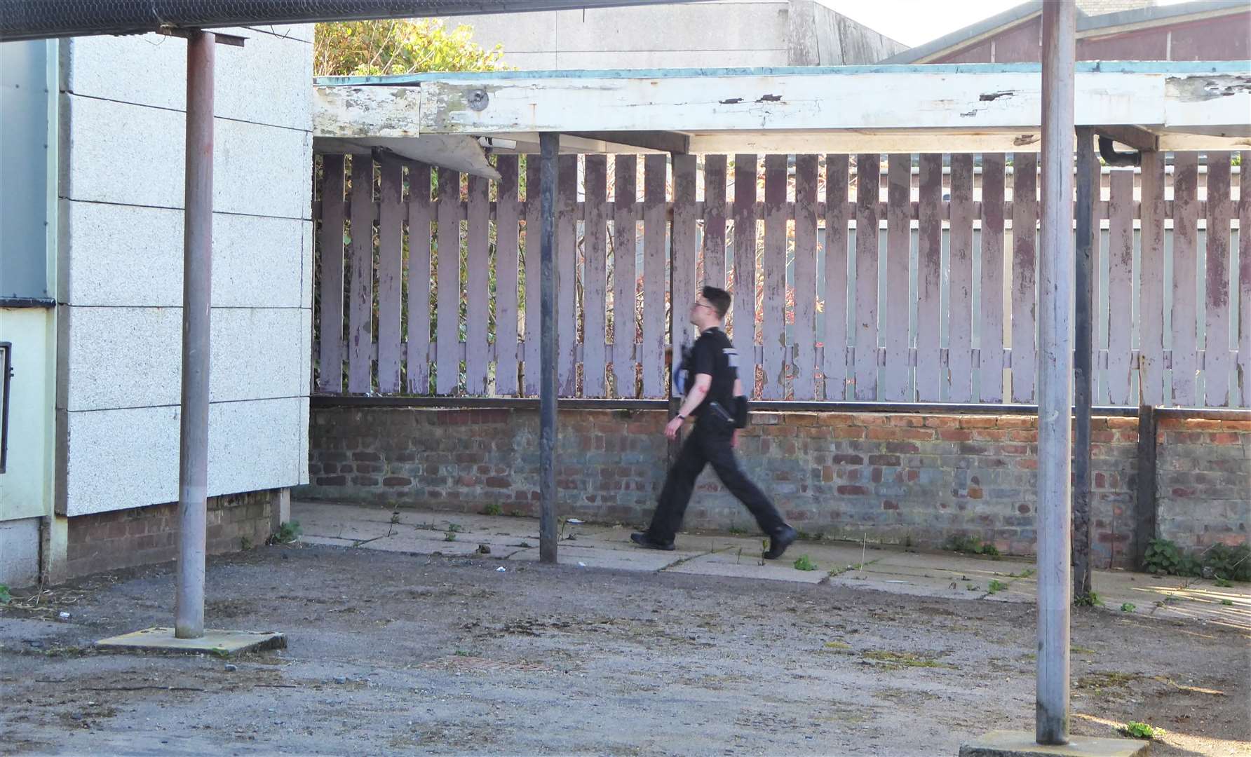 A police officer within the grounds of the empty building.
