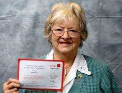 Elizabeth Mackay with badges and award certificate.