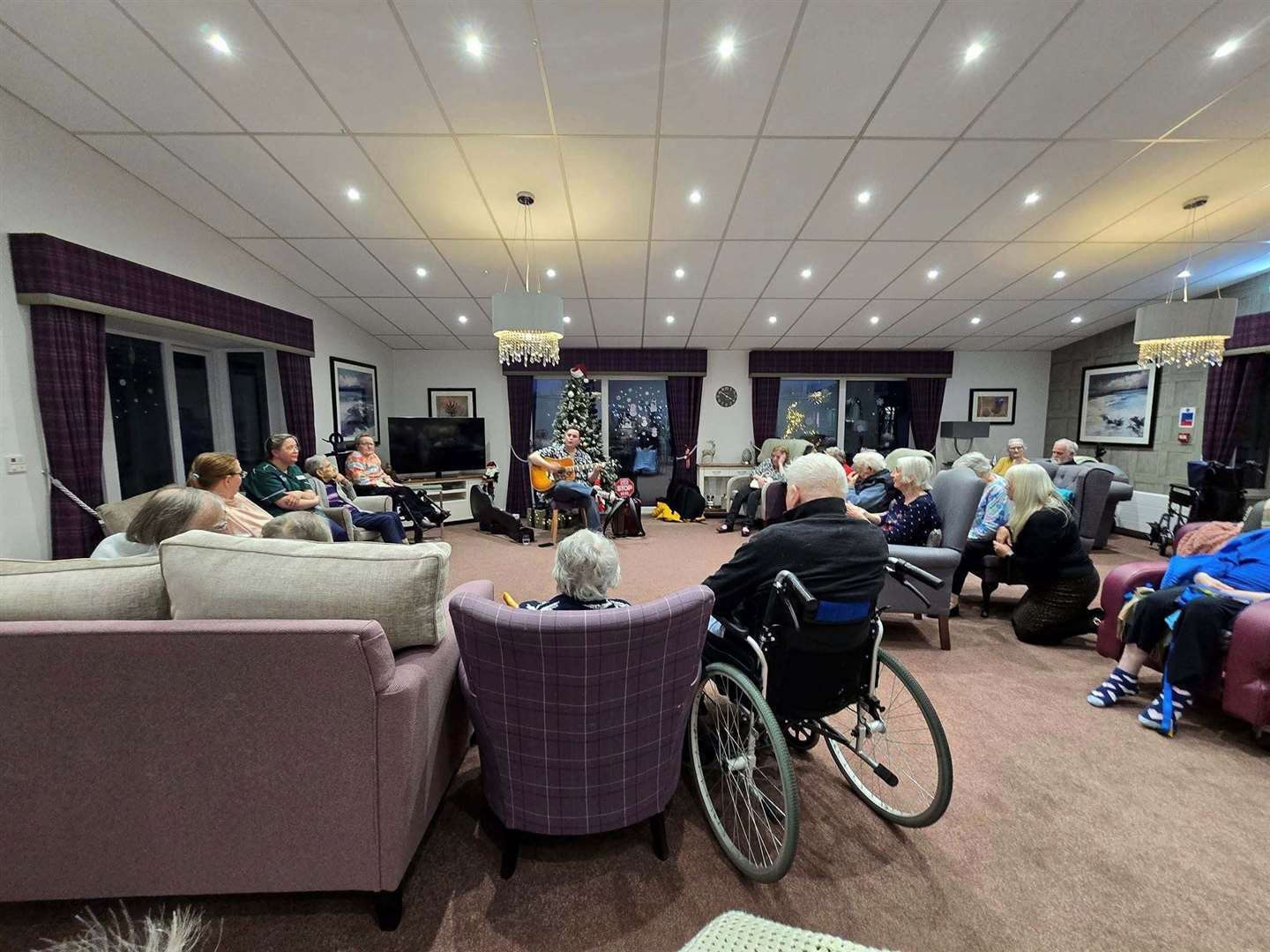 Brandon plays and sings to a full lounge.