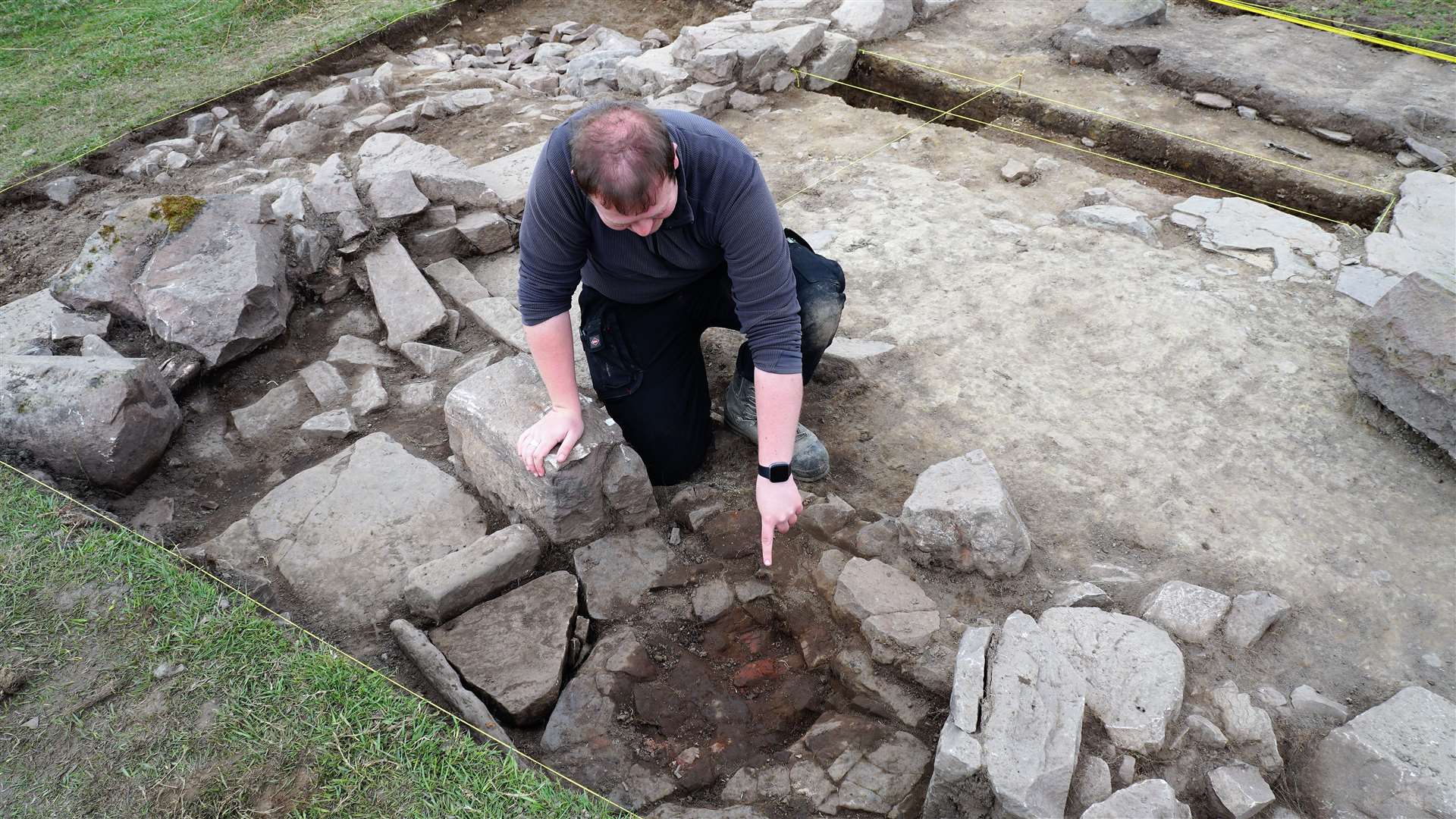 Stuart Munro, a field archaeologist with AOC Archaeology, shows what appears to be the remains of a hearth that was uncovered in the first trench. Samples of burnt material will be taken away for further analysis. Picture: DGS