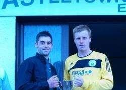 Staxigoe United captain Colin Sinclair accepting the cup from Greg Macleod.