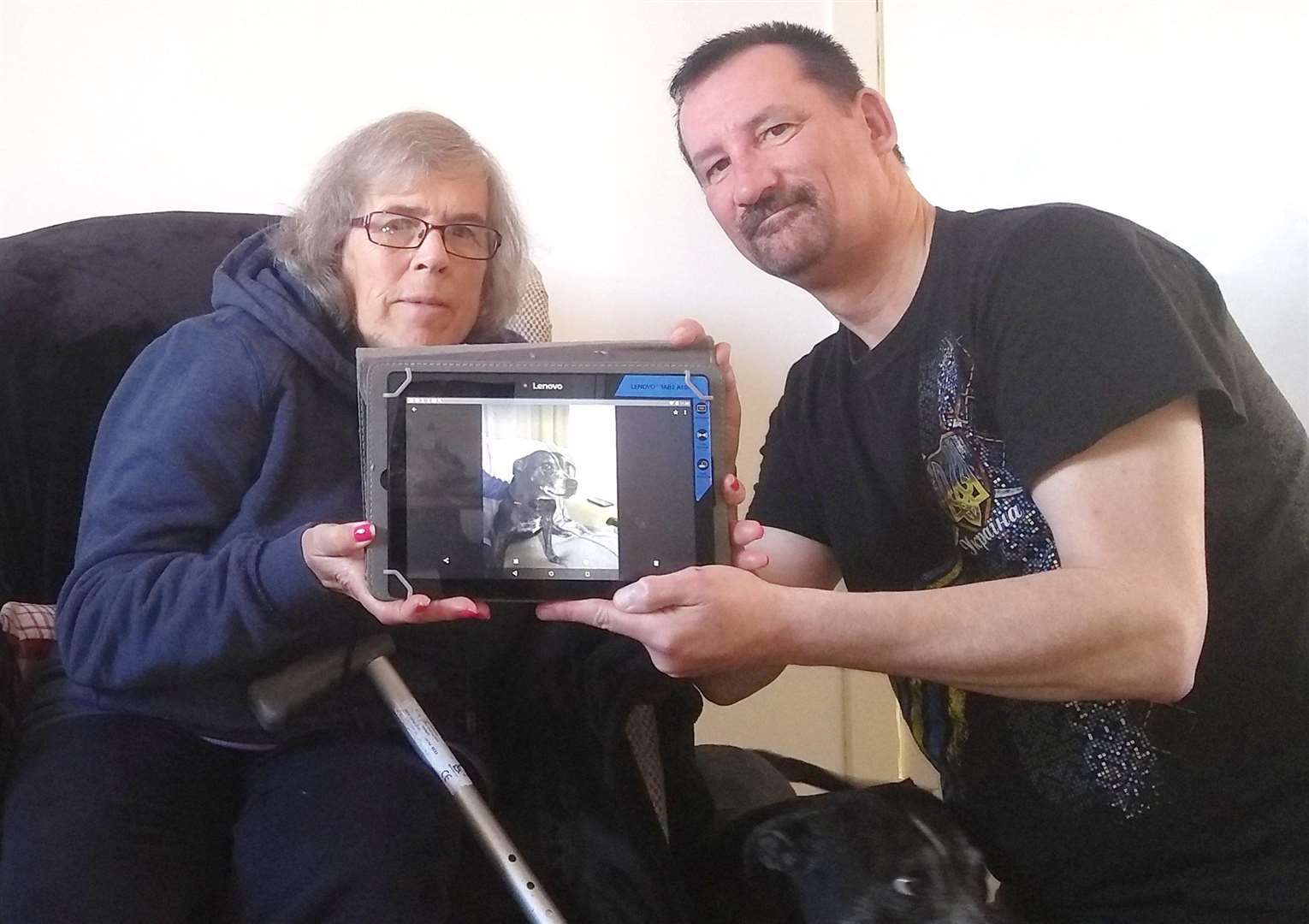 Jamie shows client Jenny from Thurso some basic computing skills such as taking photographs of her dog on a tablet device.