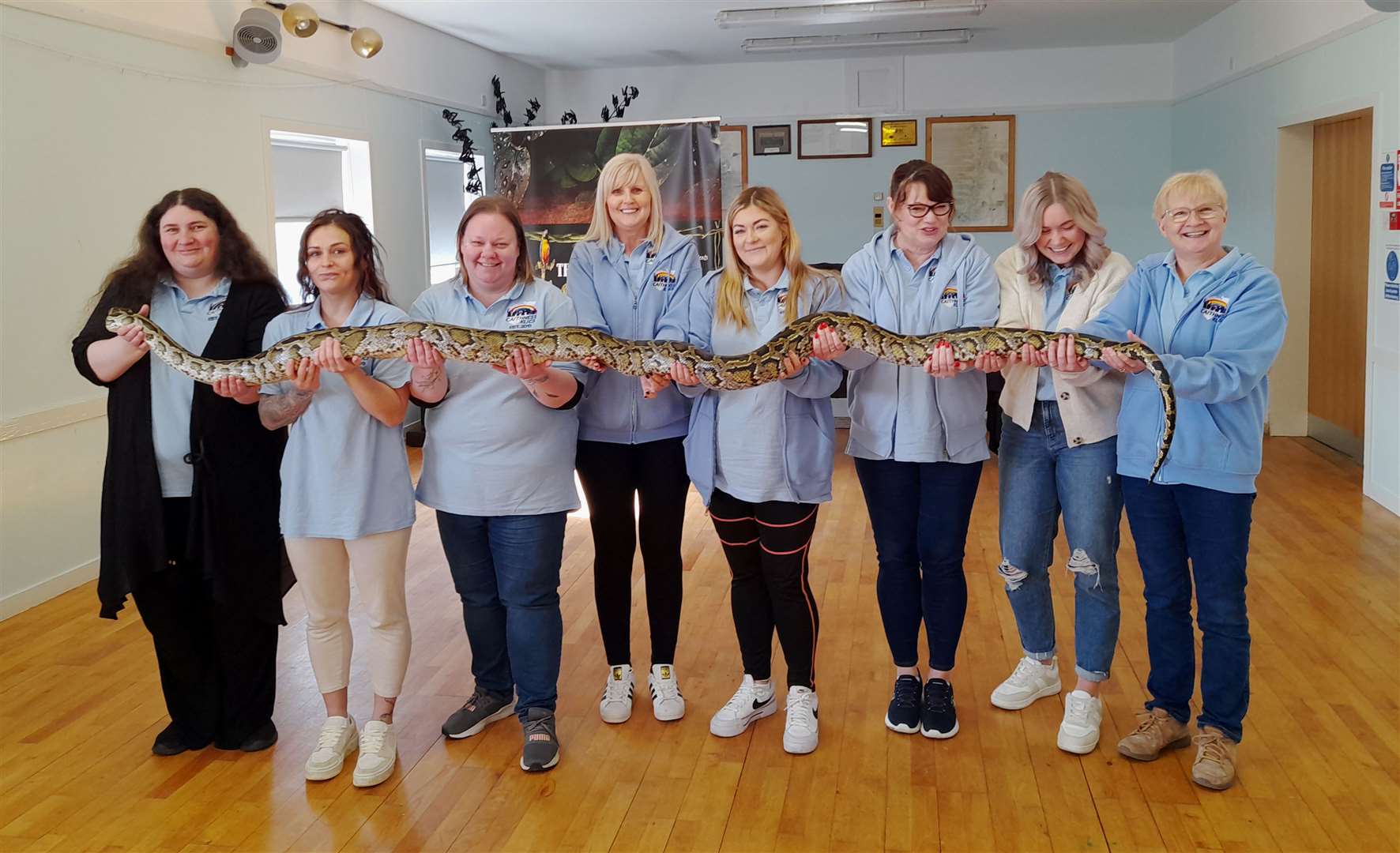 Klics staff holding Hufflepuff, the Burmese python, which extends to between 11 and 12 feet. Picture: Blair Mackenzie