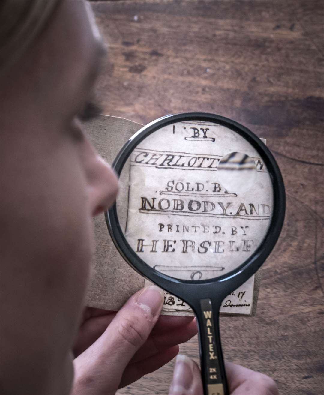 Curator Sarah Laycock uses a magnifying glass to inspect the manuscript (Danny Lawson/PA)