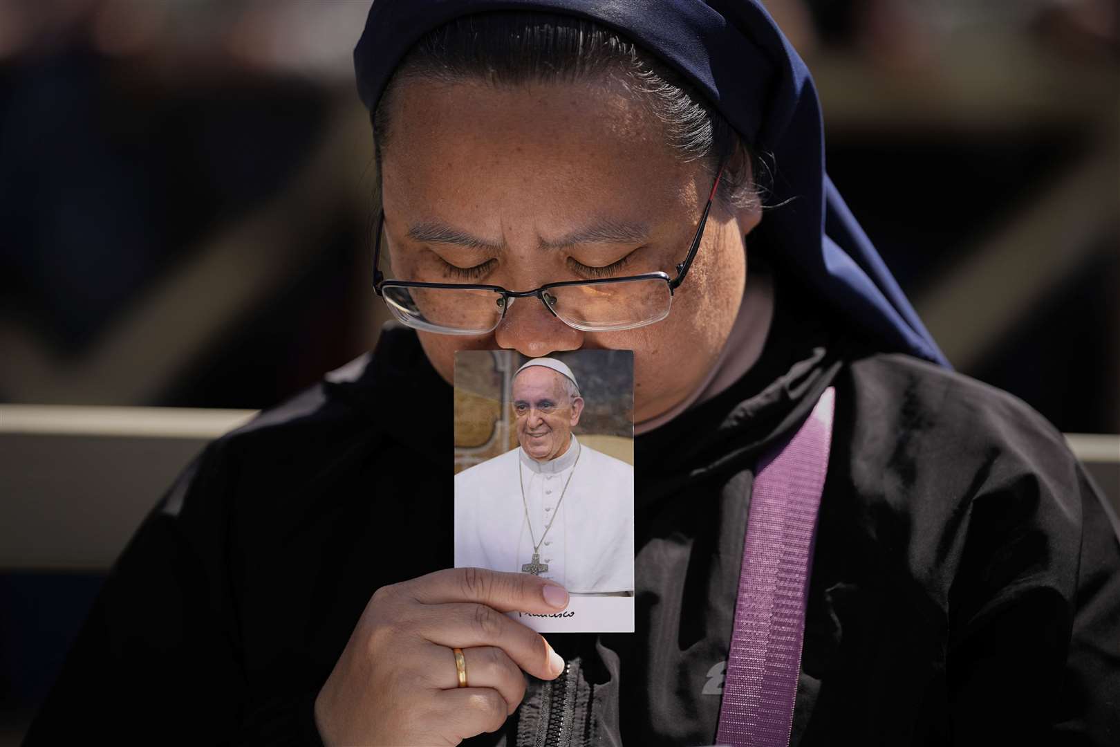 A nun holds a photo of Pope Francis while attending his funeral (Andreea Alexandru/AP)